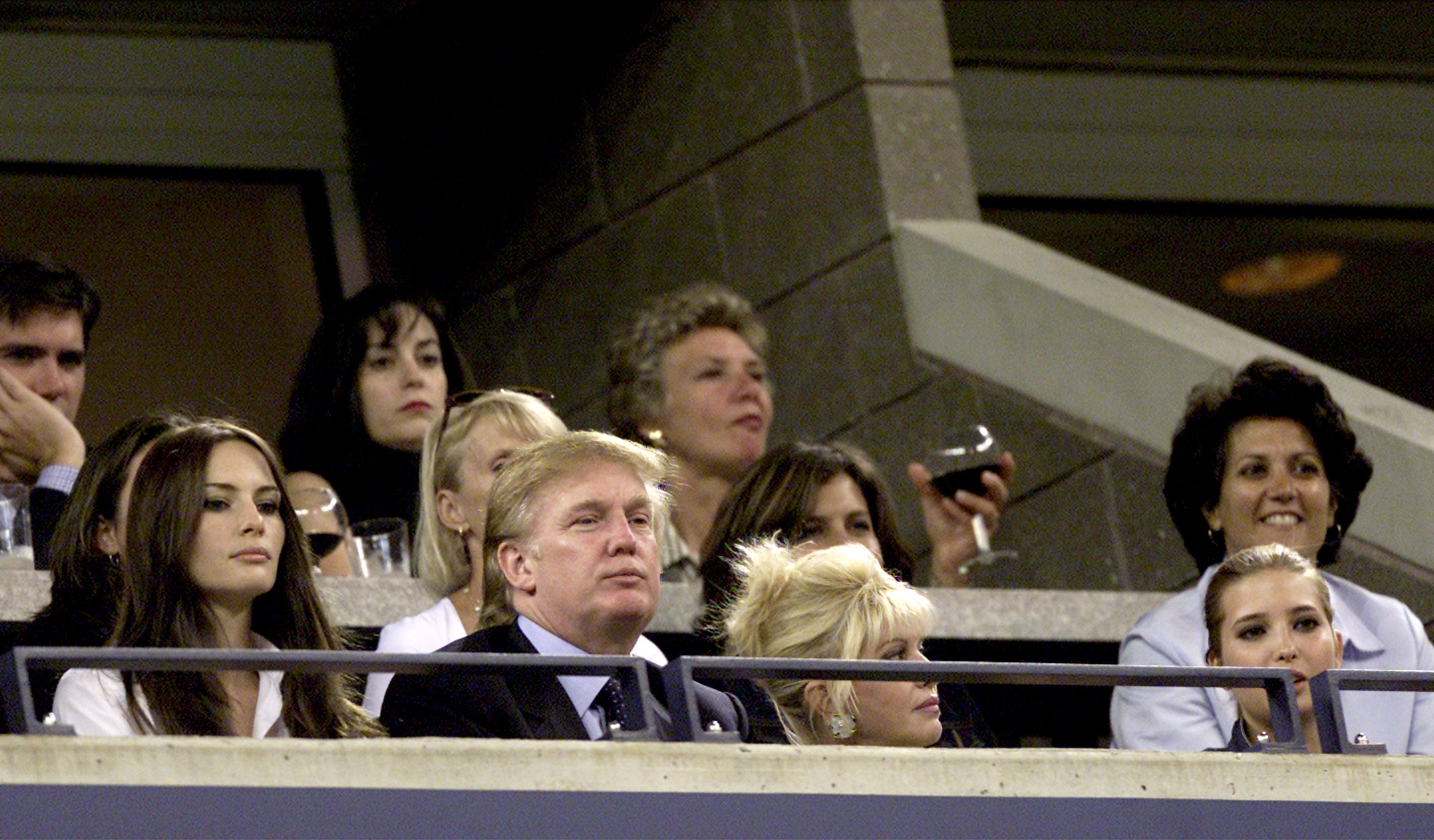 Donald Trump watches Venus and Serena Williams compete during the women's final match of the US Open with his girlfriend Melania Knauss (L), his ex-wife Ivana Trump and their daughter Ivanka (R) September 8, 2001 at the USTA National Tennis Center in Flushing, NY.