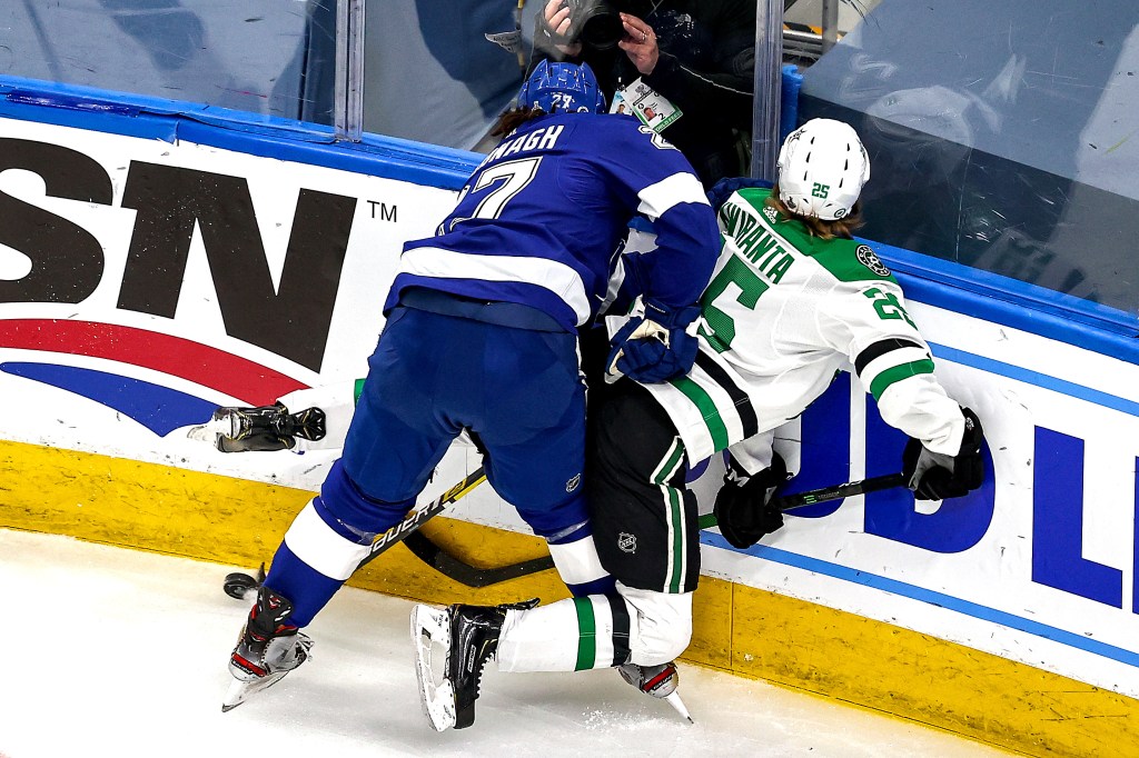 Joel Kiviranta #25 of the Dallas Stars is checked into the boards by Ryan McDonagh #27 of the Tampa Bay Lightning