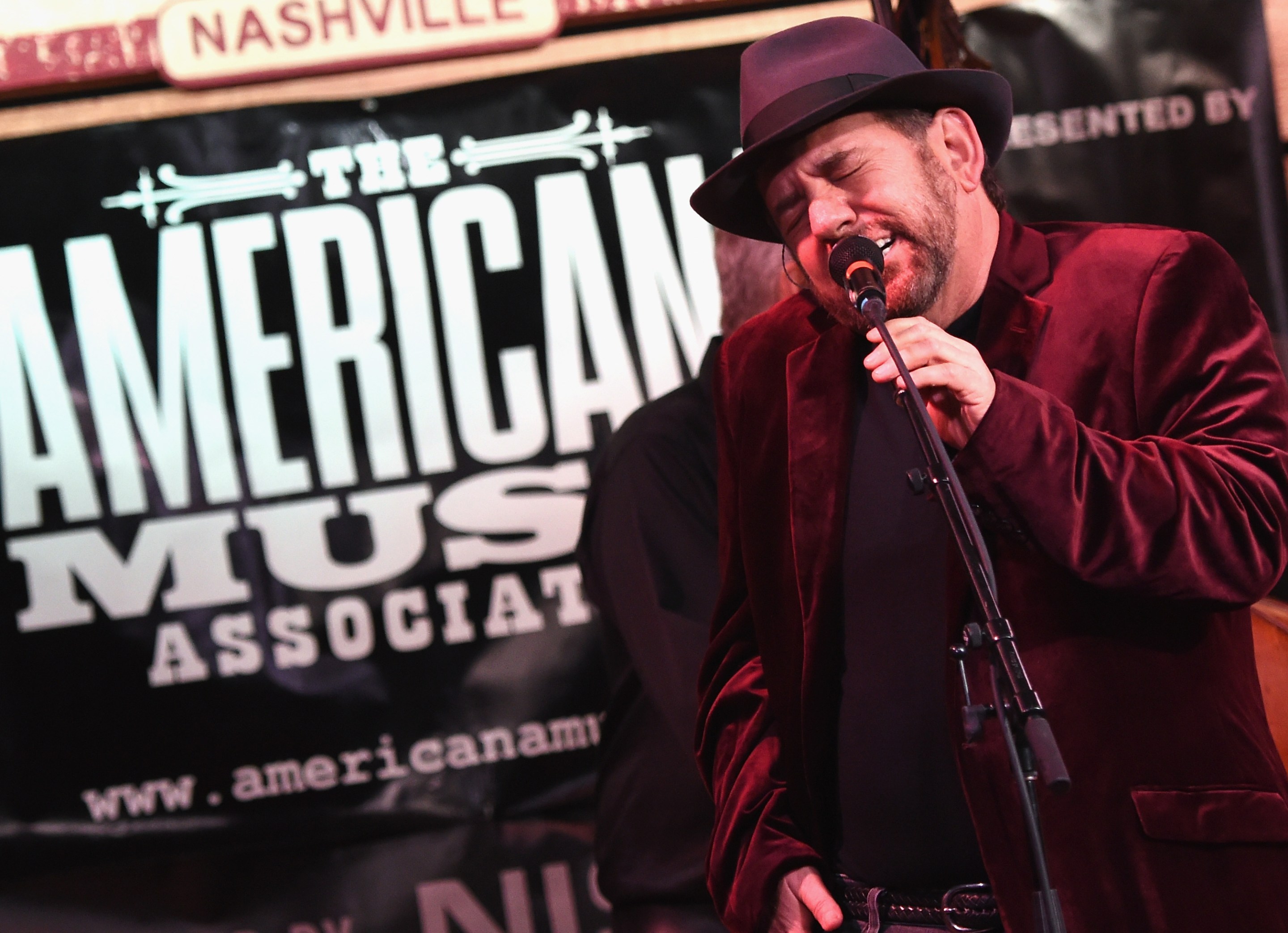 James Dolan, in a velvet blazer and a dumb hat, singing his heart out.