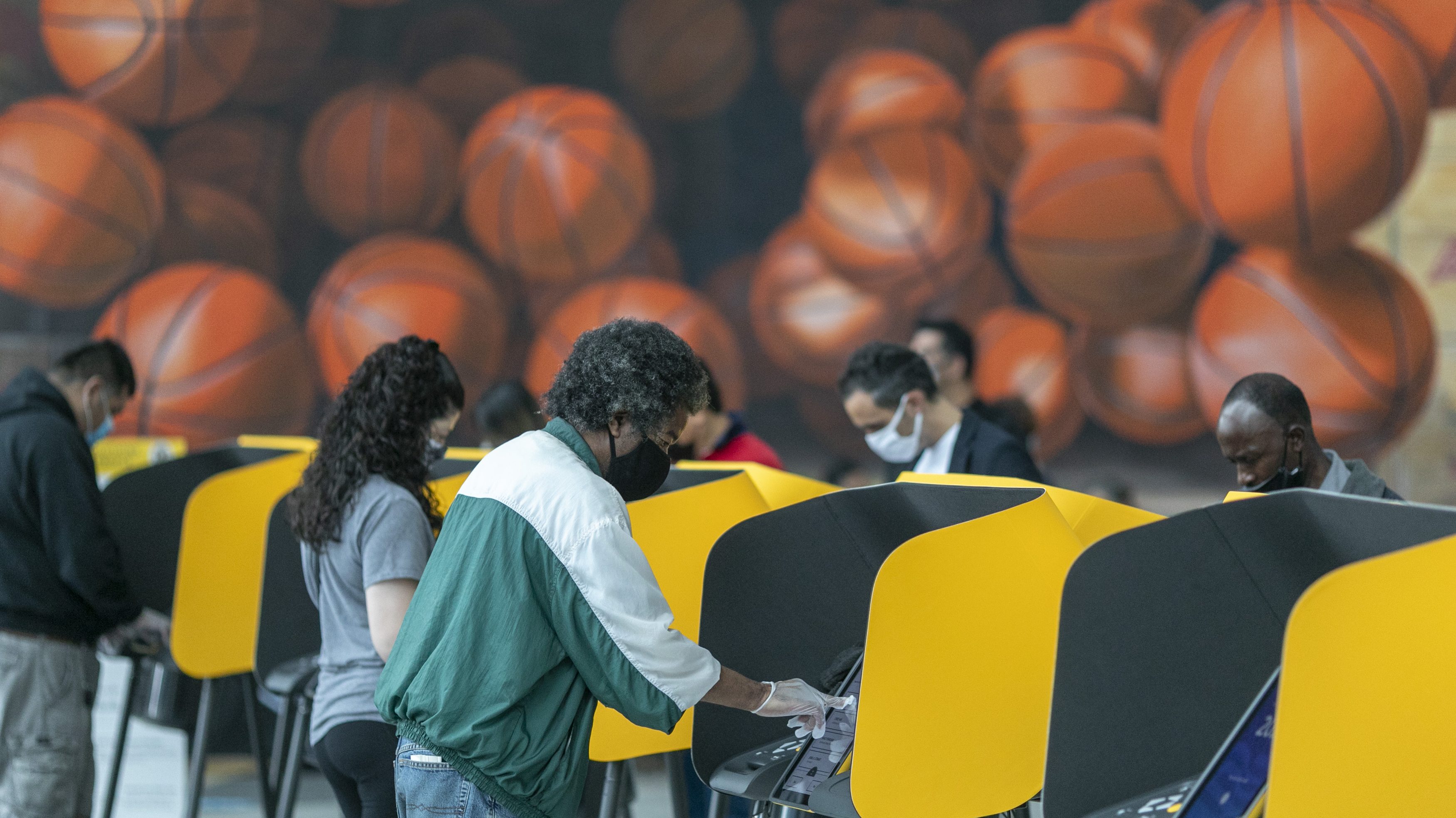 People cast their vote on the first day of early voting at the Vote Center at Staples Center sports and entertainment arena in Los Angeles, California