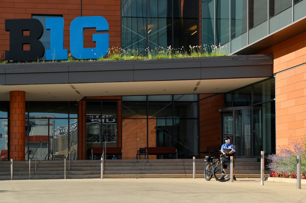 A bike cop stands outside B1G Ten headquarters in Illinois during a small protest by parents demanding a football season, in April.