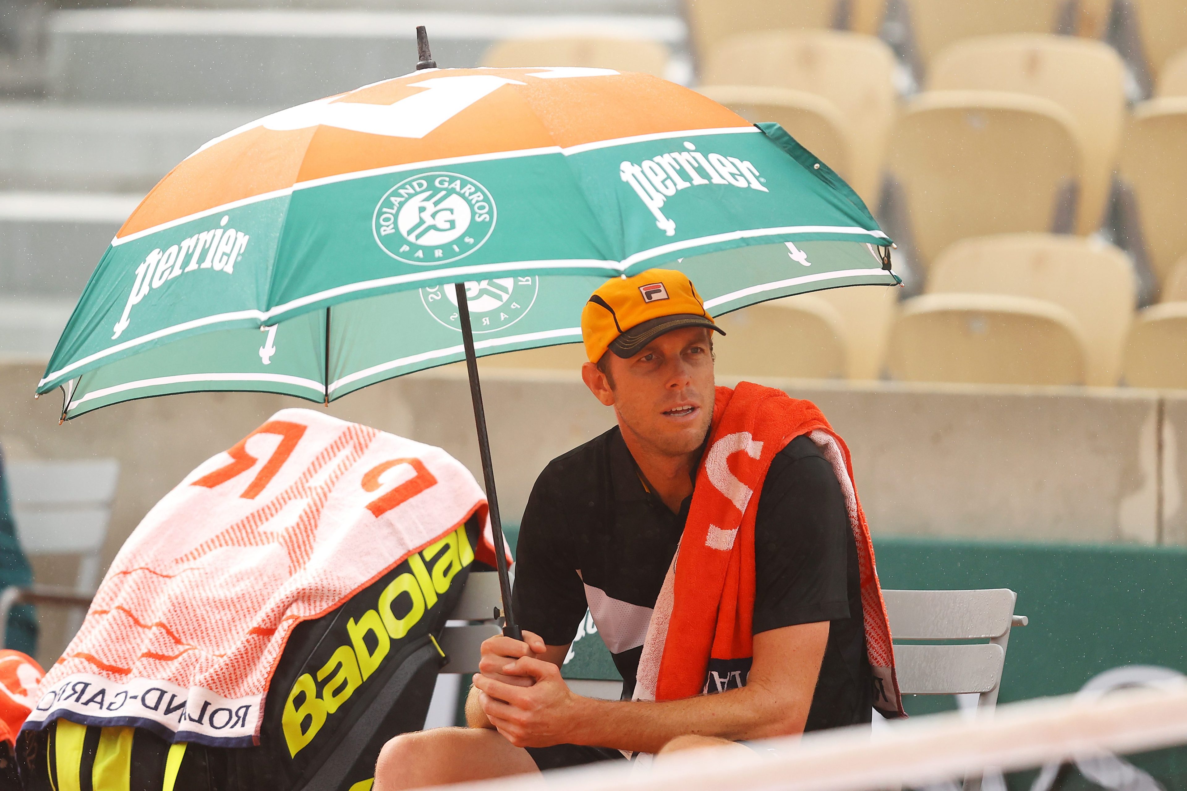 Sam Querrey sits under an umbrella at the French Open.