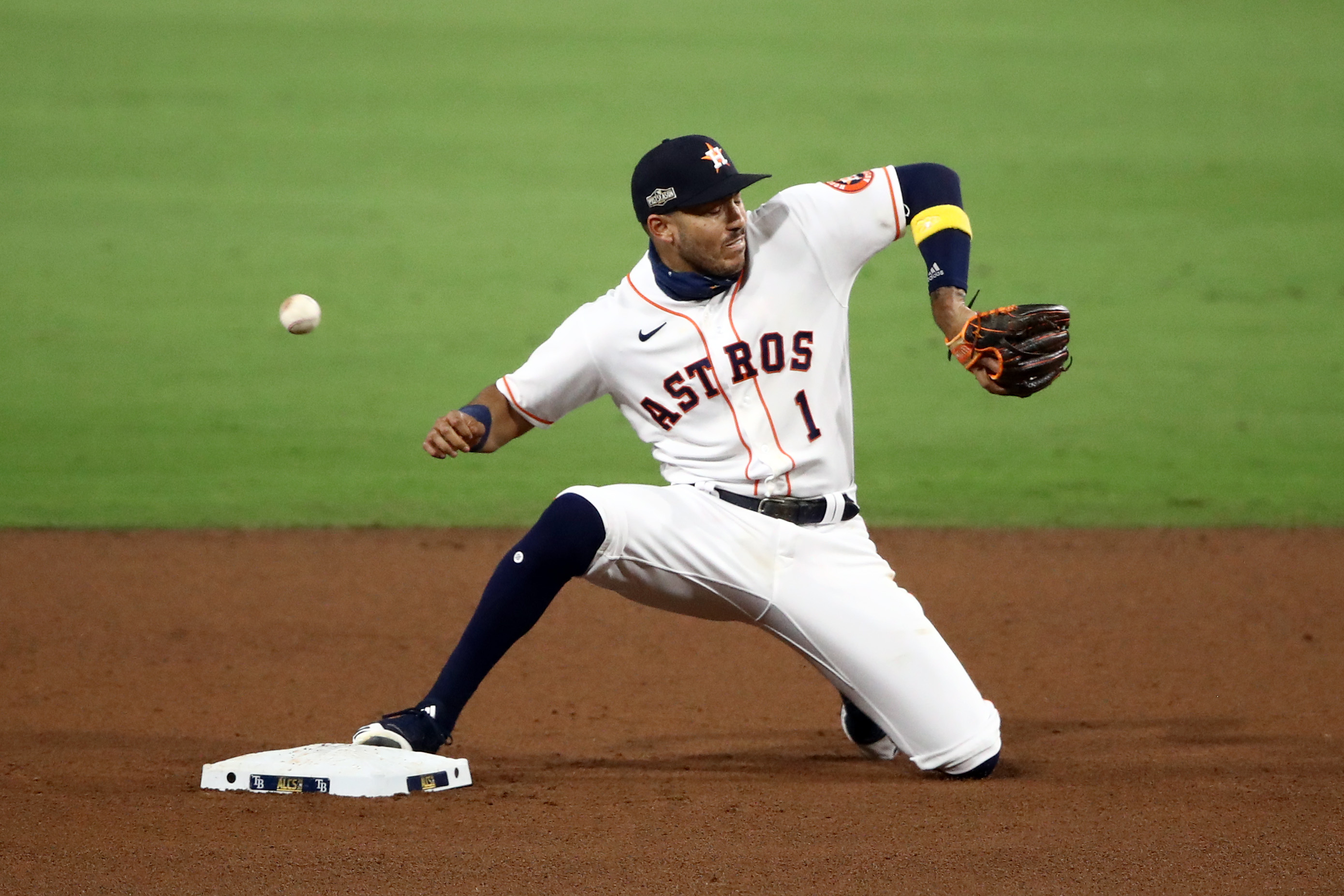 Carlos Correa #1 of the Houston Astros can't catch Jose Altuve's throw