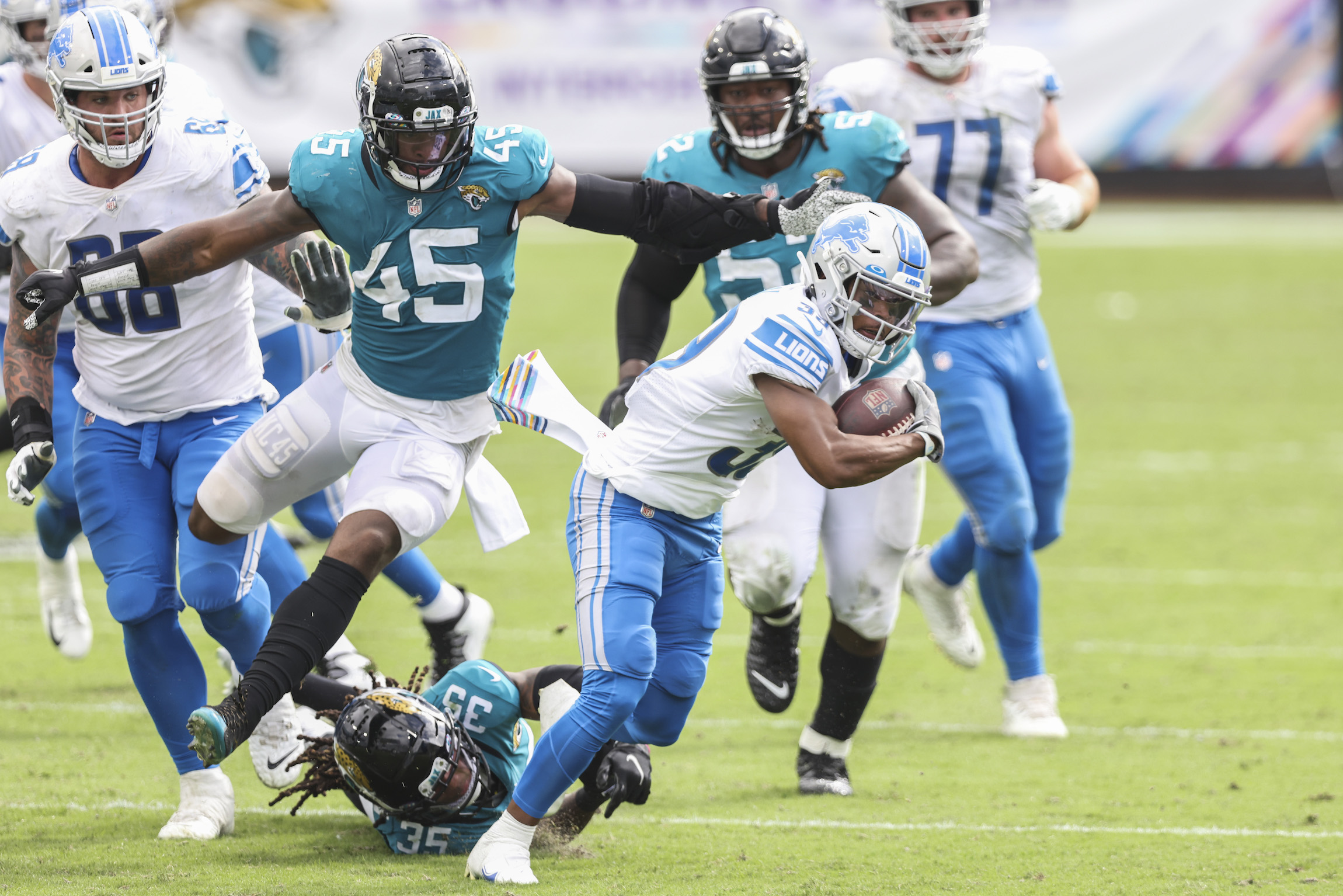 JACKSONVILLE, FLORIDA - OCTOBER 18: Jamal Agnew #39 of the Detroit Lions runs for yardage against Sidney Jones #35 and K'Lavon Chaisson #45 of the Jacksonville Jaguars during the first half of a game at TIAA Bank Field on October 18, 2020 in Jacksonville, Florida. (Photo by James Gilbert/Getty Images)