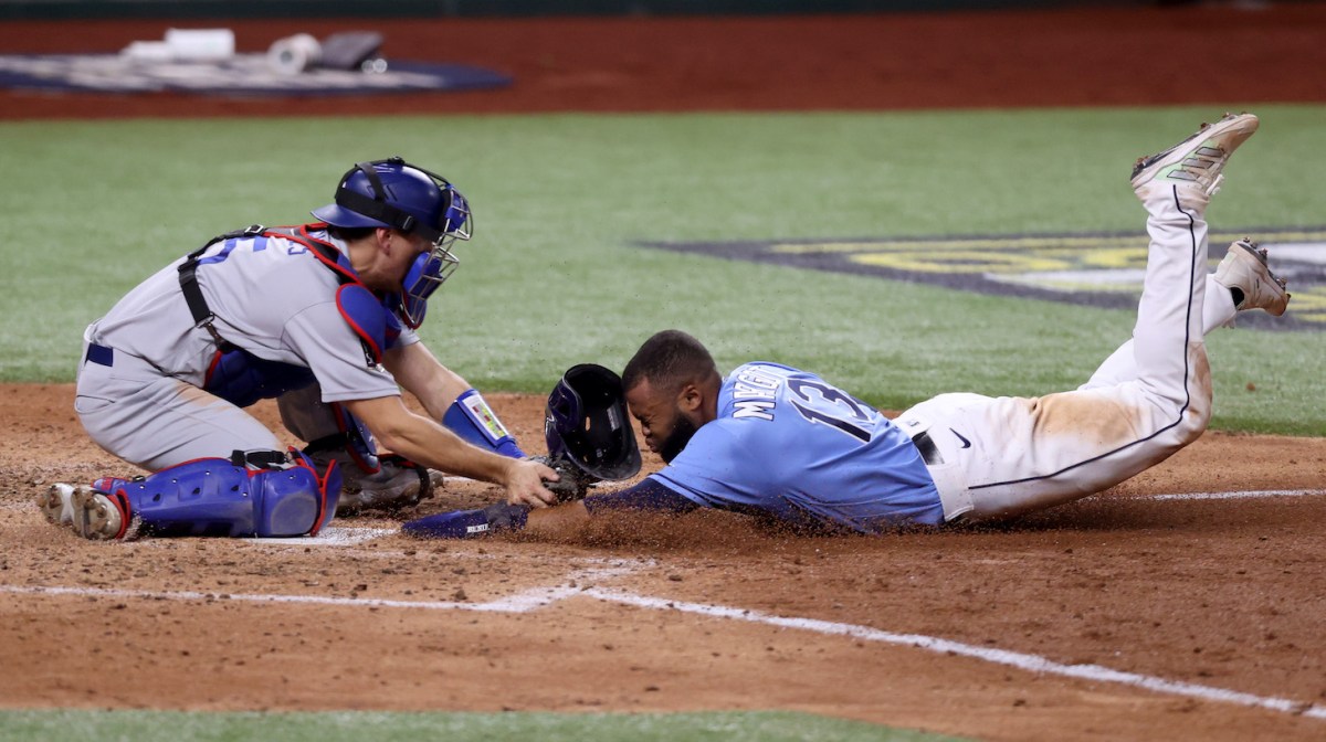 ARLINGTON, TEXAS - OCTOBER 25: Manuel Margot #13 of the Tampa Bay Rays is tagged out by Austin Barnes #15 of the Los Angeles Dodgers on an attempt to steal home during the fourth inning in Game Five of the 2020 MLB World Series at Globe Life Field on October 25, 2020 in Arlington, Texas. (Photo by Tom Pennington/Getty Images)