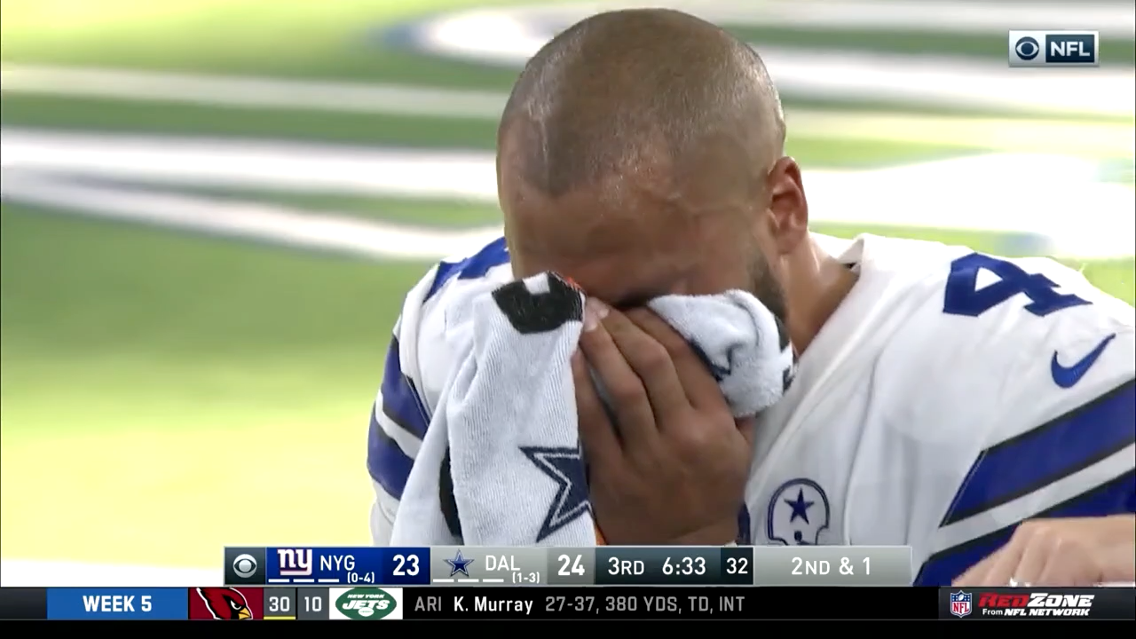 Dak Prescott covers his face with a towel as he leaves the field after his injury