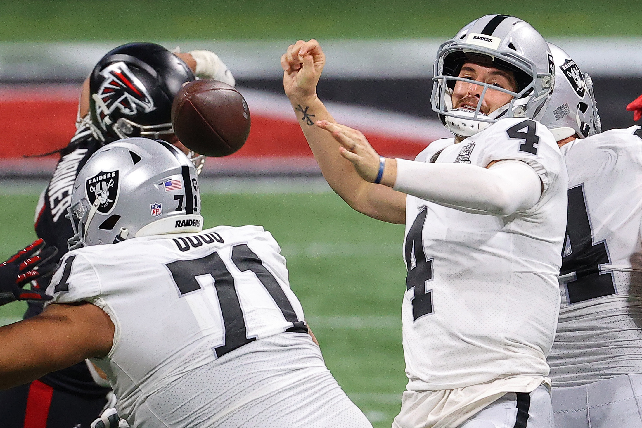 Derek Carr #4 of the Las Vegas Raiders is stripped of the ball during their NFL game against the Atlanta Falcons at Mercedes-Benz Stadium on November 29, 2020 in Atlanta, Georgia.