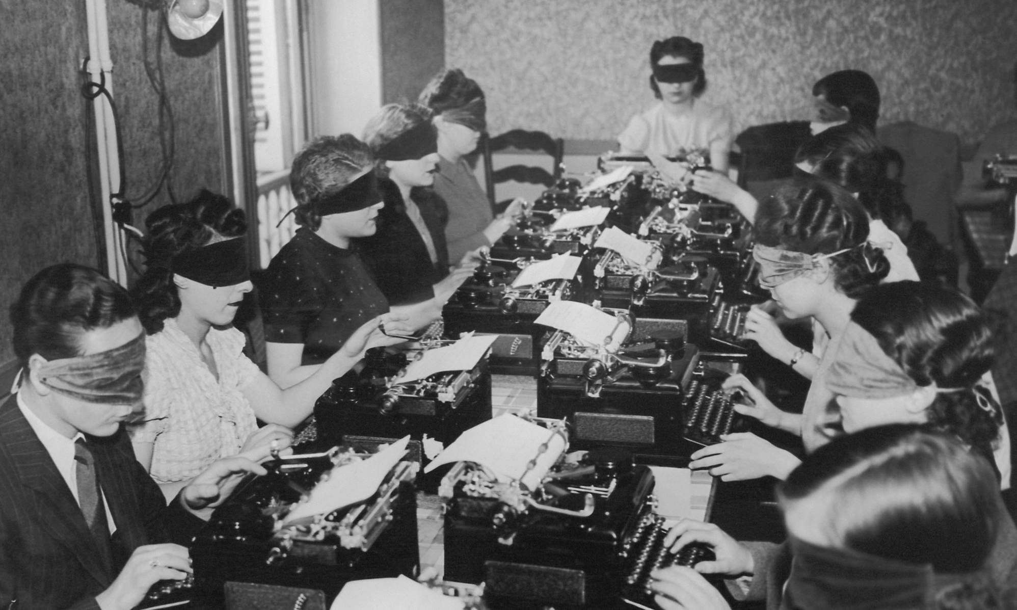 Some old-timey types type at typewriters while blindfolded.