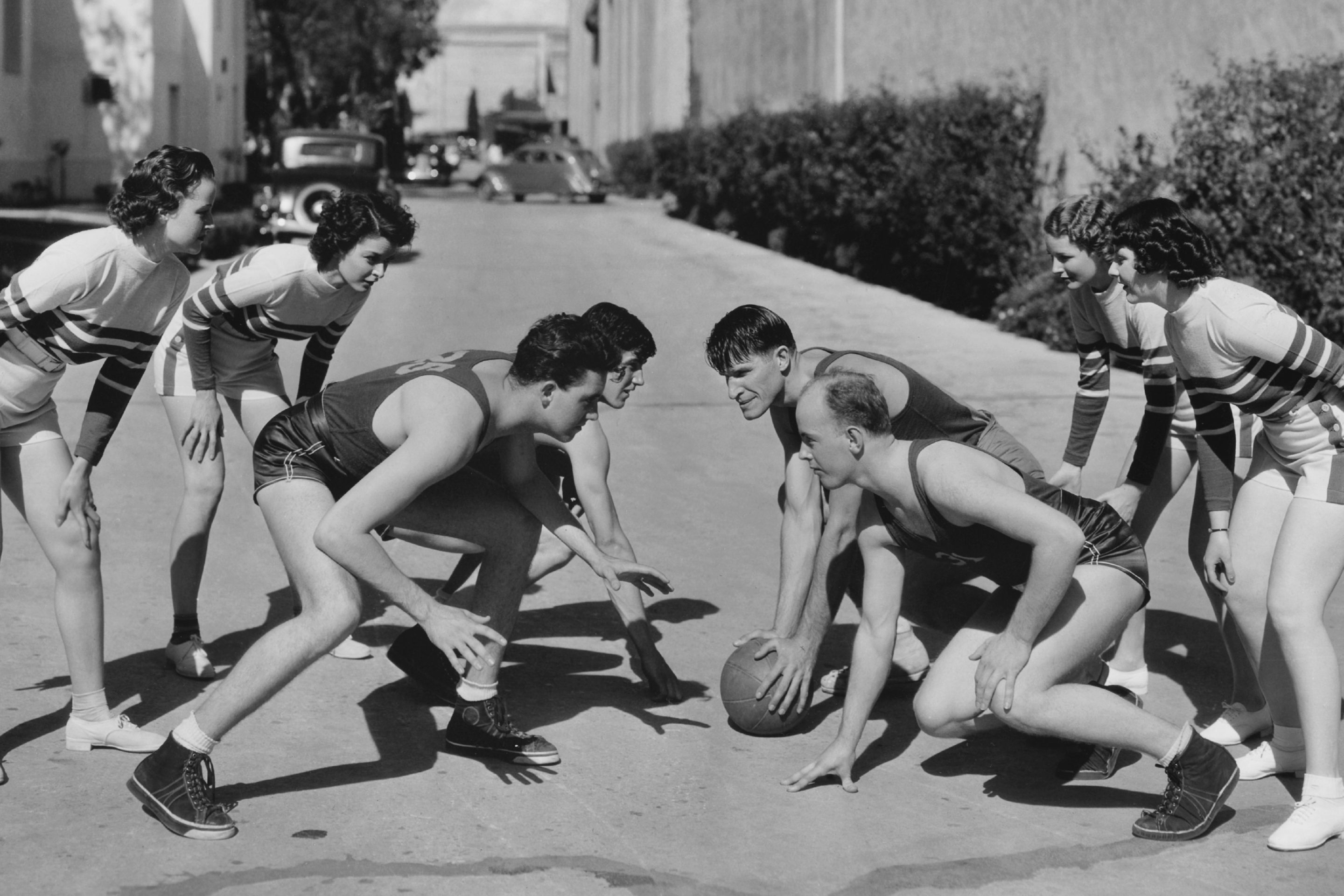 Old-time basketball players, in what appears to be an alley in Los Angeles maybe
