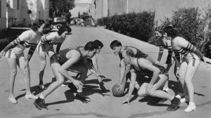 Old-time basketball players, in what appears to be an alley in Los Angeles maybe