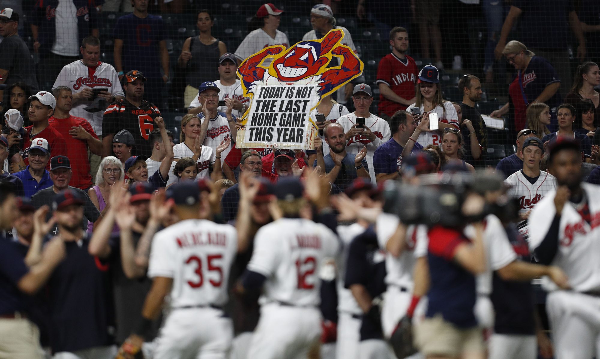 Fans hold up a Chief Wahoo sign at a Cleveland baseball game.