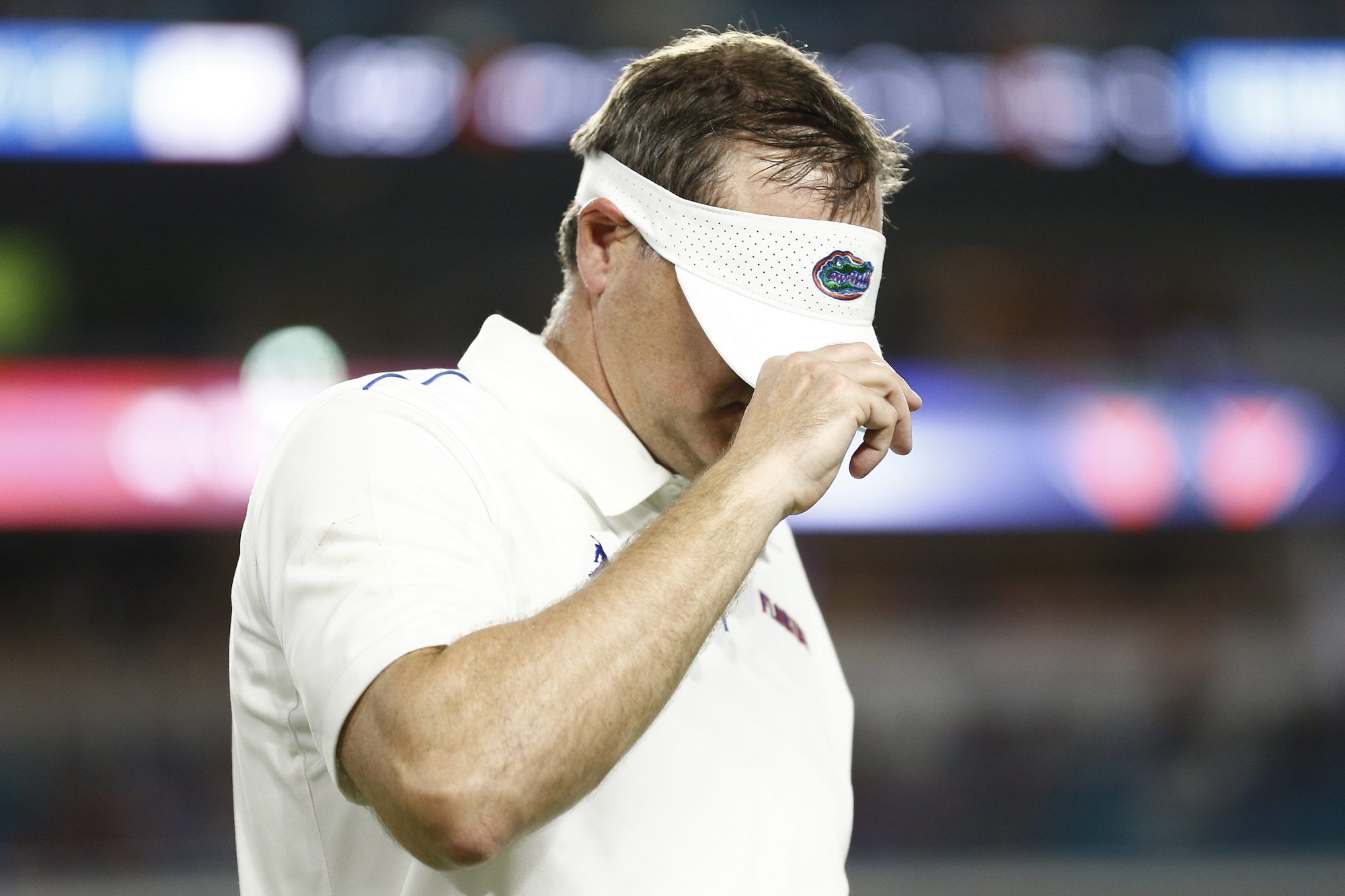 Dan Mullen, in happier times, covers his face with a visor.