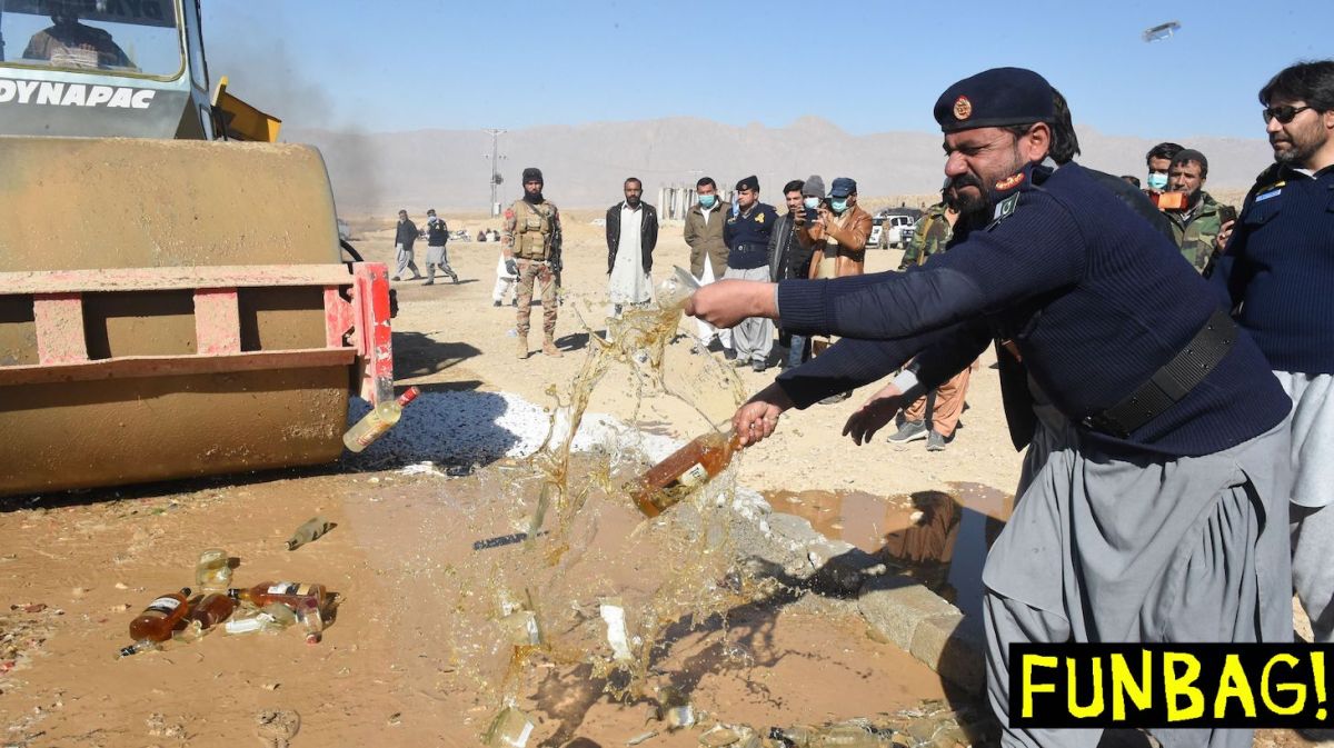 Custom official destroys seized bottles of liquor, previously smuggled into Pakistan during an ceremony organized by customs to destroy seized alcohol and drugs smuggled into Pakistan, on the outskirts of Quetta on December 15, 2020.   (Photo by Banaras KHAN / AFP) (Photo by BANARAS KHAN/AFP via Getty Images)