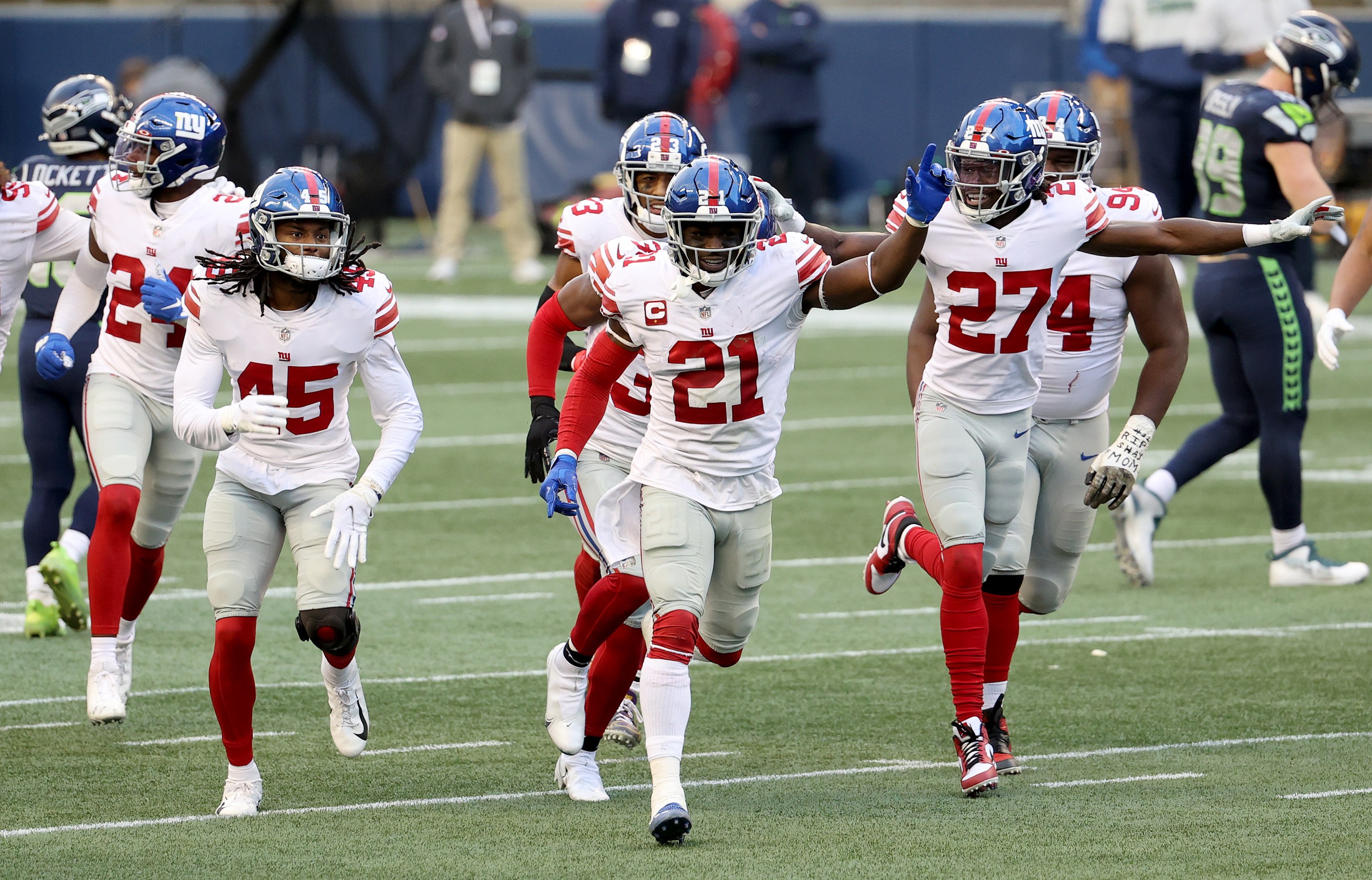 Madre Harper #45, Jabrill Peppers #21 and Isaac Yiadom #27 of the New York Giants celebrate an interception