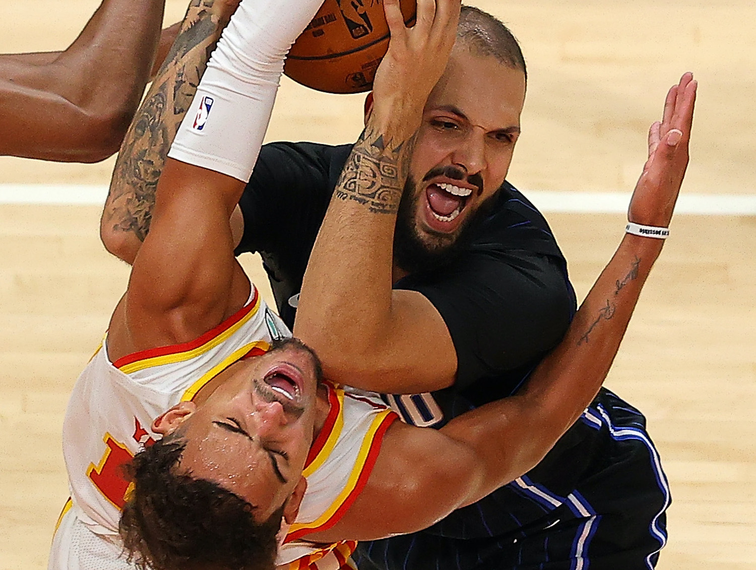 ATLANTA, GEORGIA - DECEMBER 13: Trae Young #11 of the Atlanta Hawks draws an offensive foul from Evan Fournier #10 of the Orlando Magic during a preseason game at State Farm Arena on December 13, 2020 in Atlanta, Georgia. NOTE TO USER: User expressly acknowledges and agrees that, by downloading and or using this photograph, User is consenting to the terms and conditions of the Getty Images License Agreement. (Photo by Kevin C. Cox/Getty Images)
