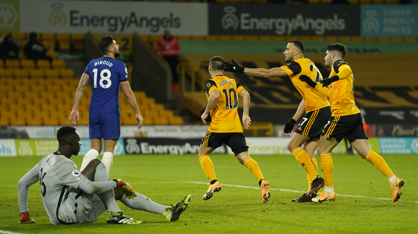 Daniel Podence of Wolverhampton Wanderers celebrates with teammates Romain Saiss and Pedro Neto after scoring their team's first goal during the Premier League match between Wolverhampton Wanderers and Chelsea at Molineux on December 15, 2020 in Wolverhampton, England. The match will be played without fans, behind closed doors as a Covid-19 precaution.