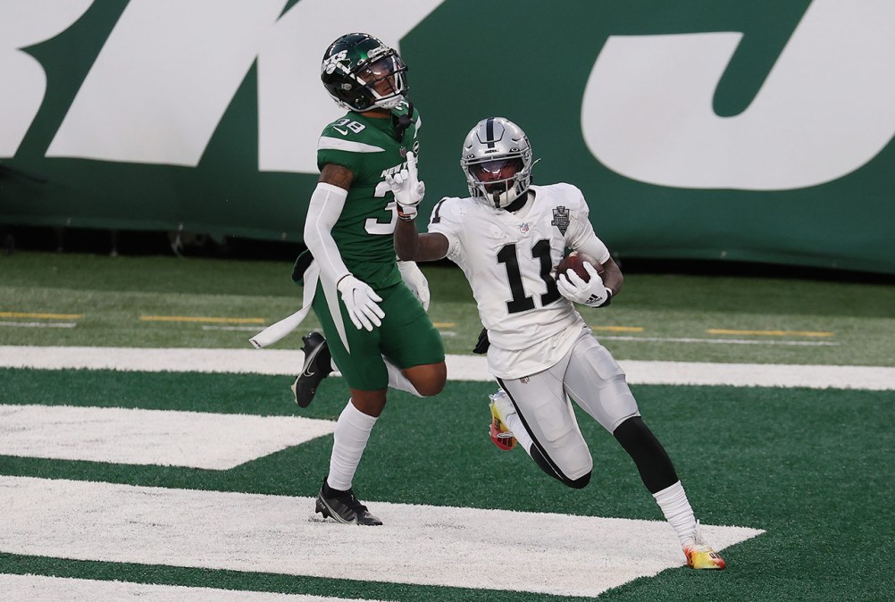 No. 11 on the Raiders celebrates in the end zone as a Jets player sighs behind him