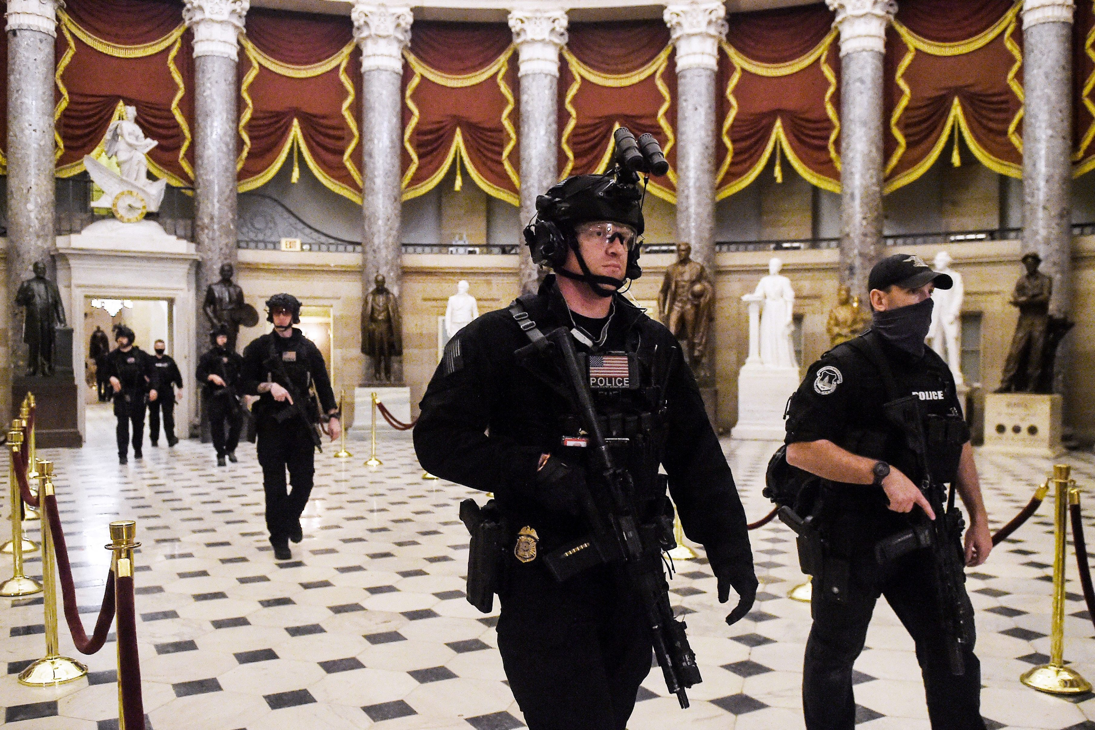 Members of the Swat team patrol and secure the Statuary Hall