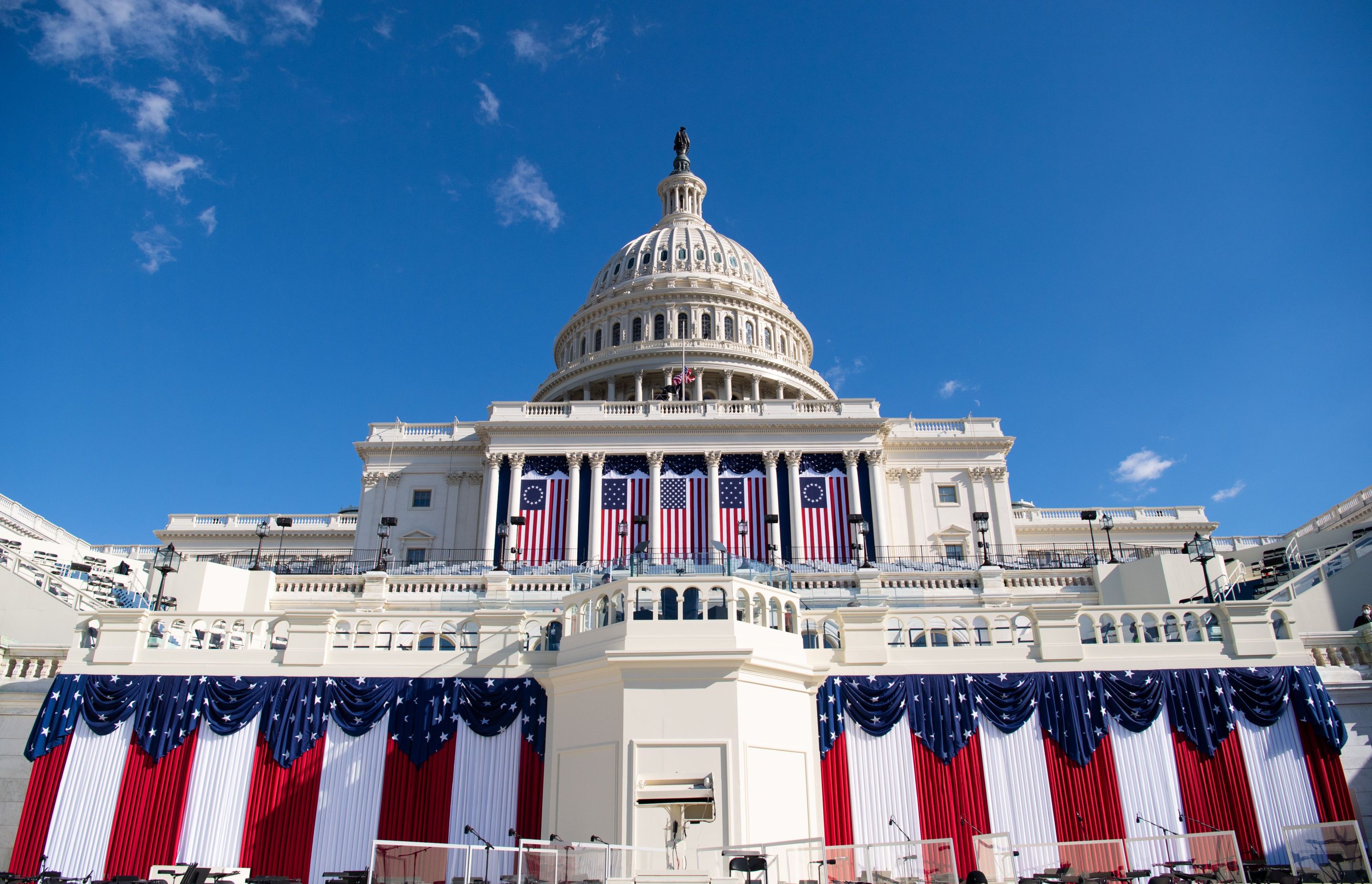 the US capitol shot from low near the ground and decorated with american flags