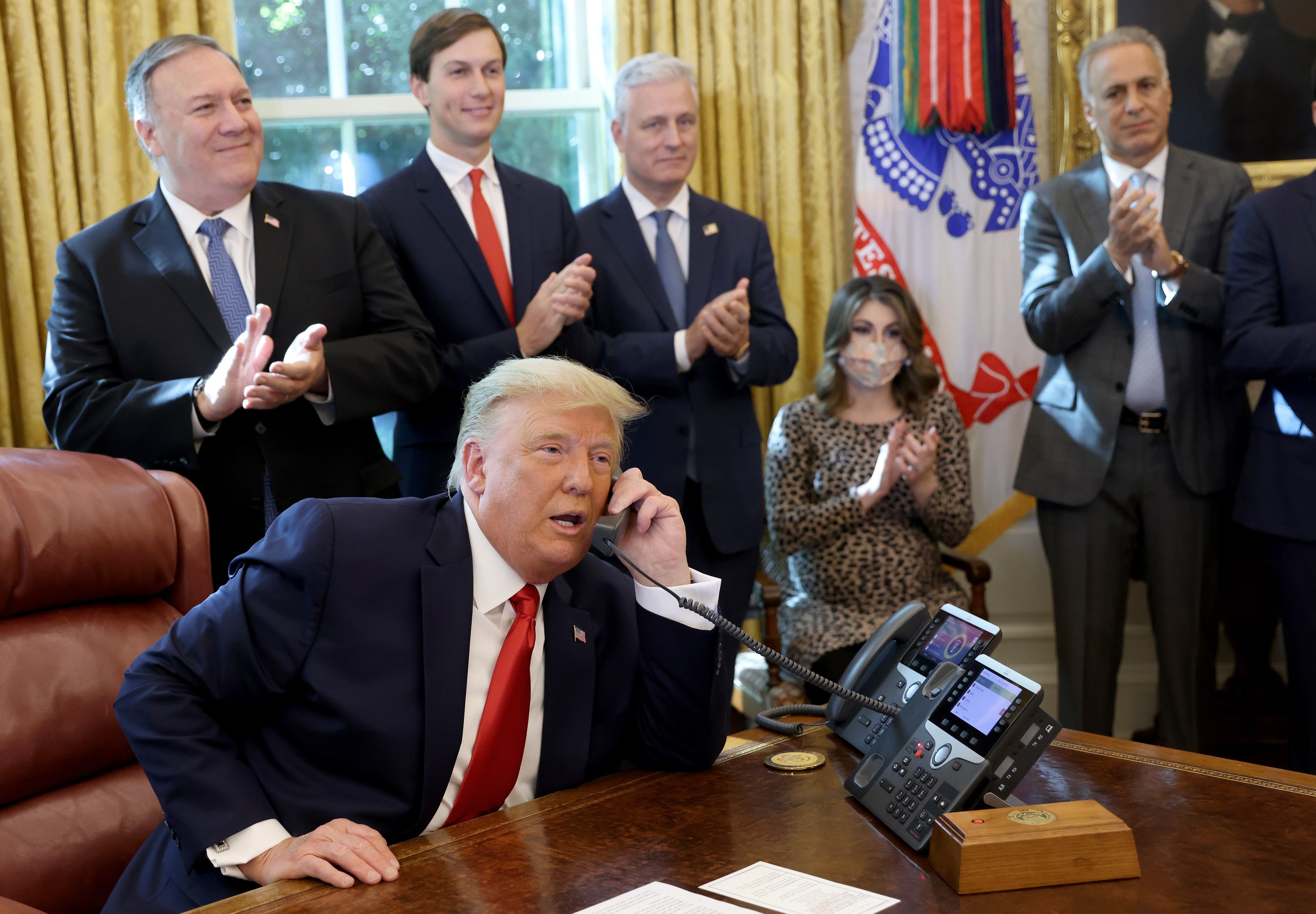 Donald Trump on the phone being applauded by lackeys, presumably not for farting.