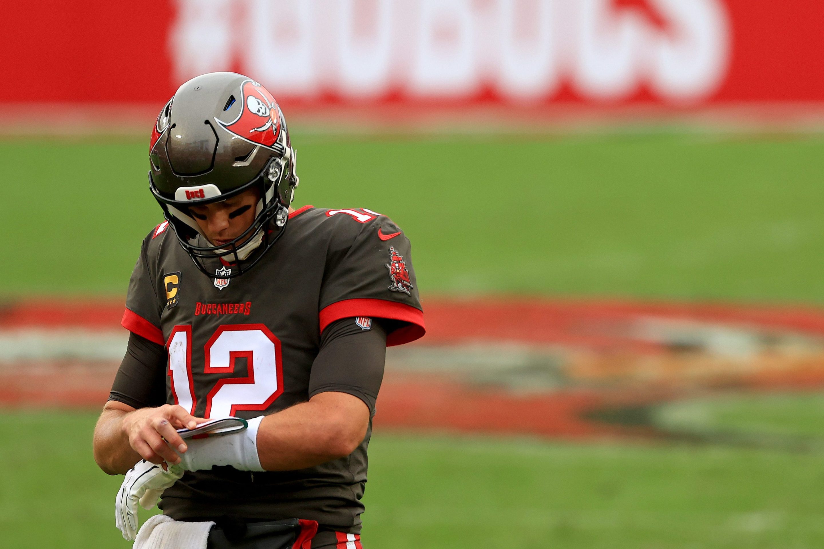 Quarterback Tom Brady looks down at his wristband during a Tampa Bay Buccaneers game.