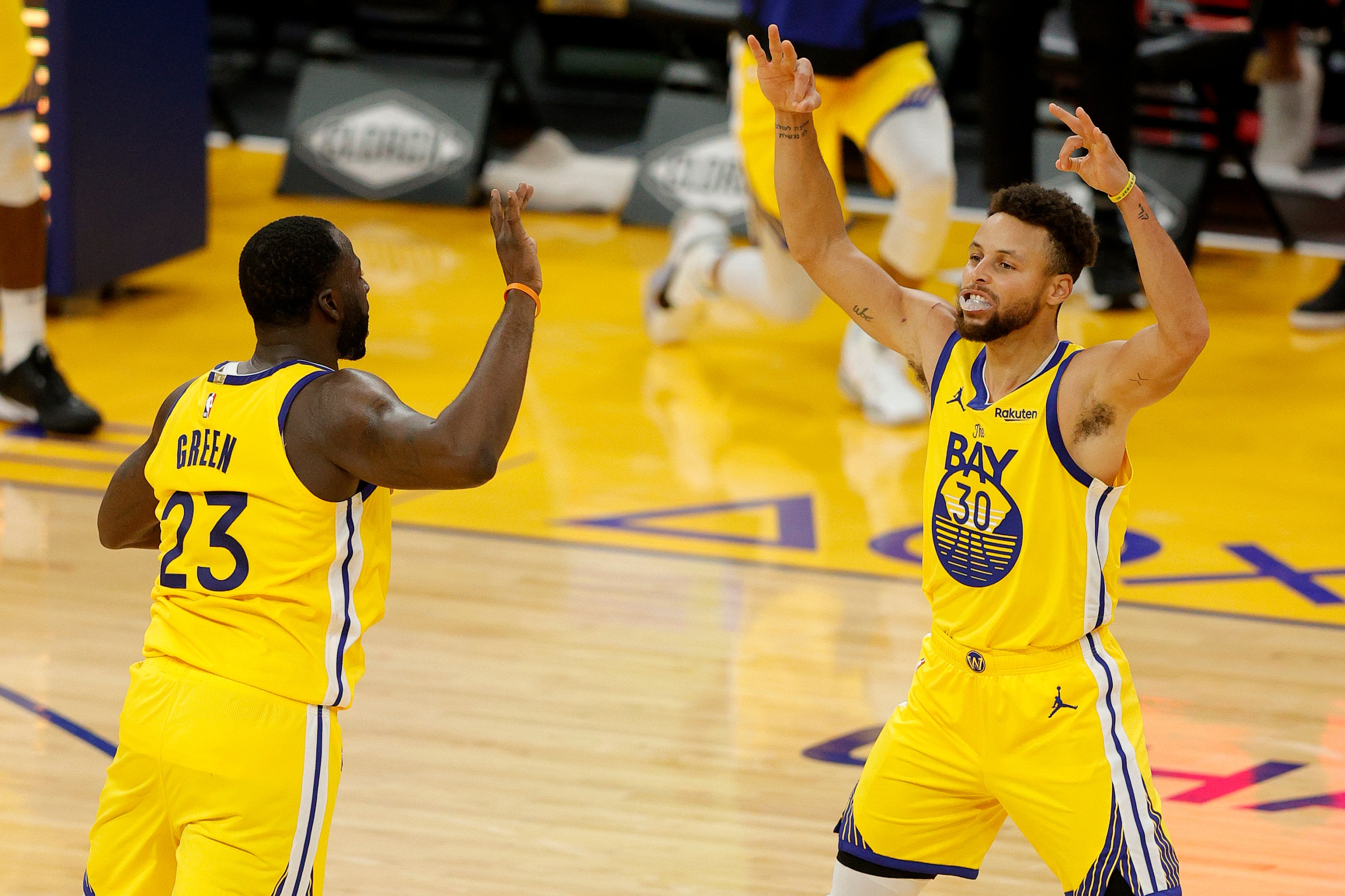 Steph Curry celebrates a make with Draymond Green.