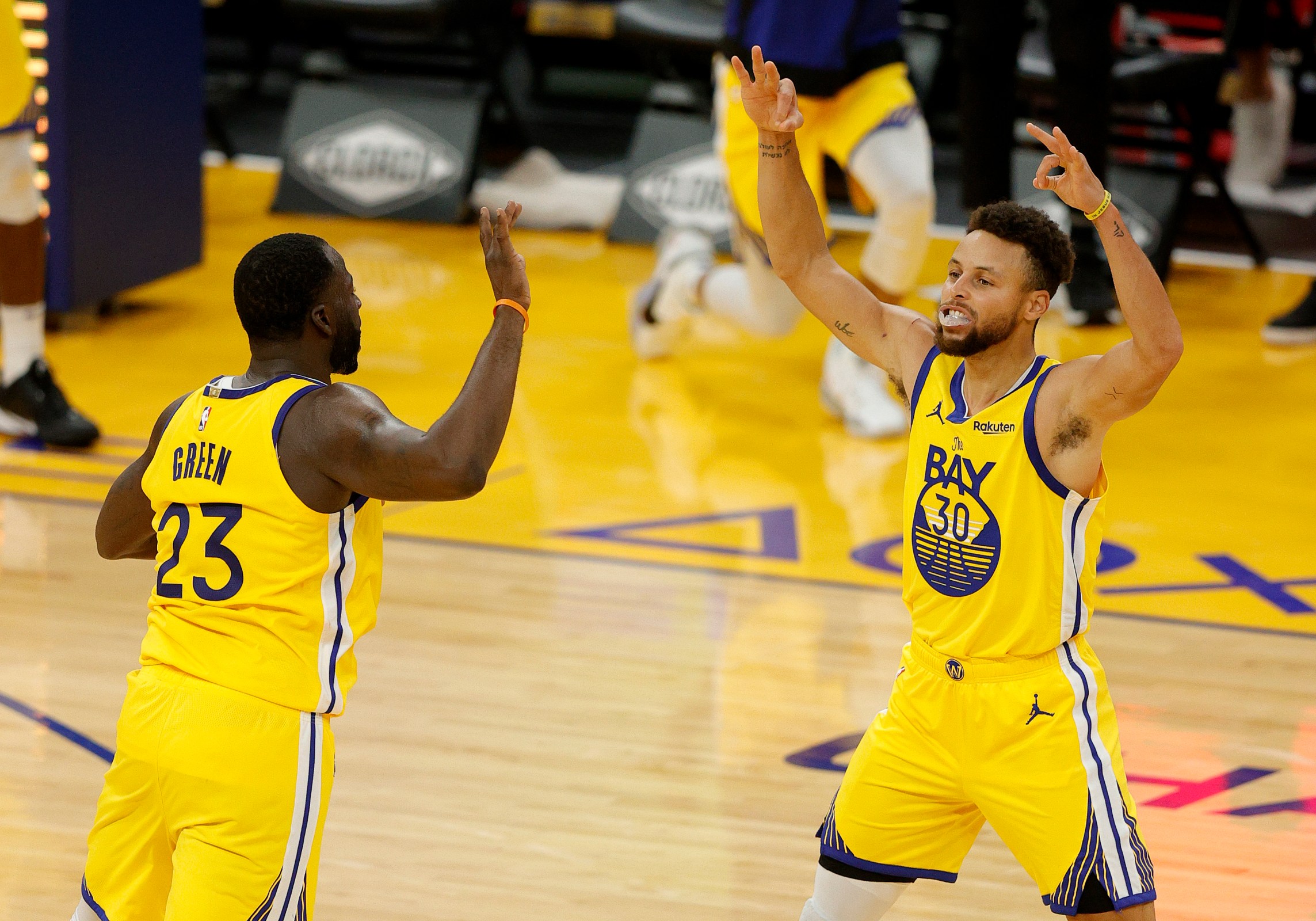 Steph Curry celebrates a make with Draymond Green.