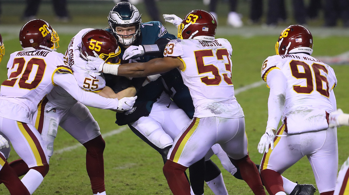 PHILADELPHIA, PENNSYLVANIA - JANUARY 03: Quarterback Nate Sudfeld #7 of the Philadelphia Eagles is tackled by linemen Cole Holcomb #55, Jon Bostic #53 and Jimmy Moreland #20 of the Washington Football Team in the fourth quarter of the game at Lincoln Financial Field on January 03, 2021 in Philadelphia, Pennsylvania. (Photo by Mitchell Leff/Getty Images)