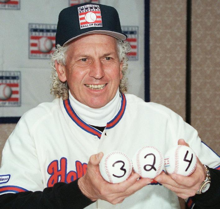 The late Don Sutton holding three baseballs marked to reflect the 324 games he won during his Hall of Fame career.