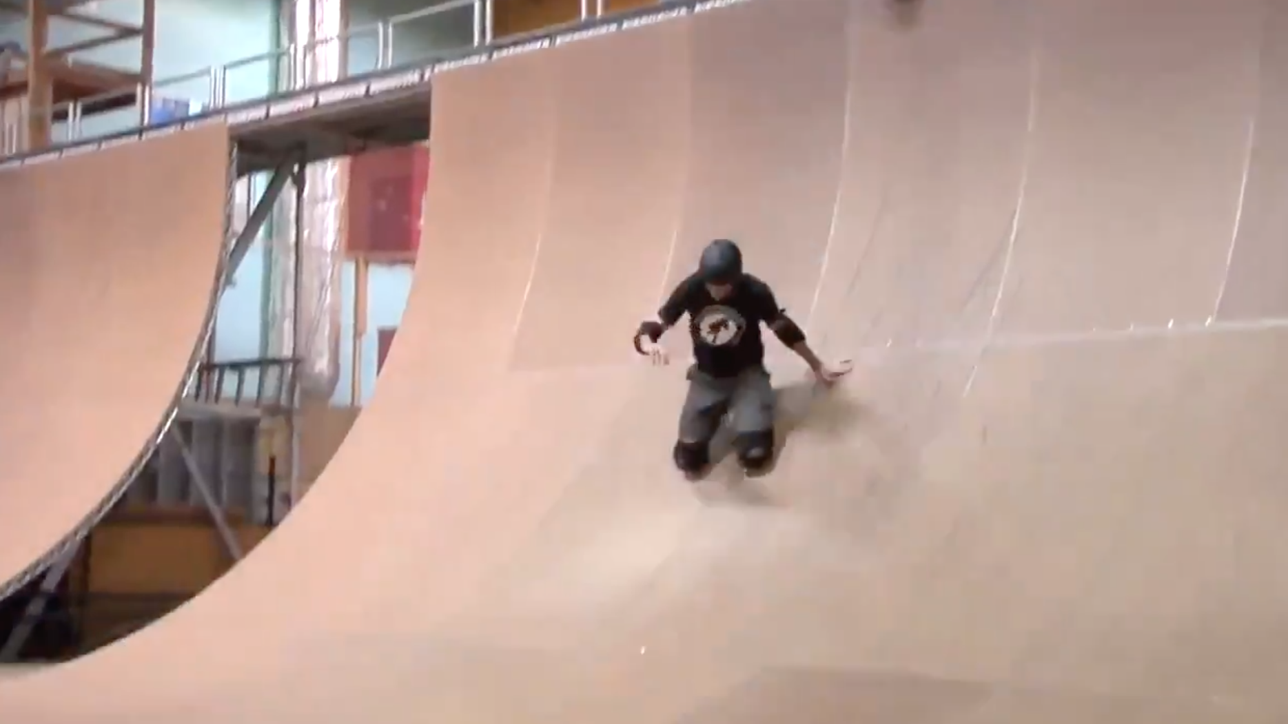 tony hawk slides on his knee pads down the side of a half pipe