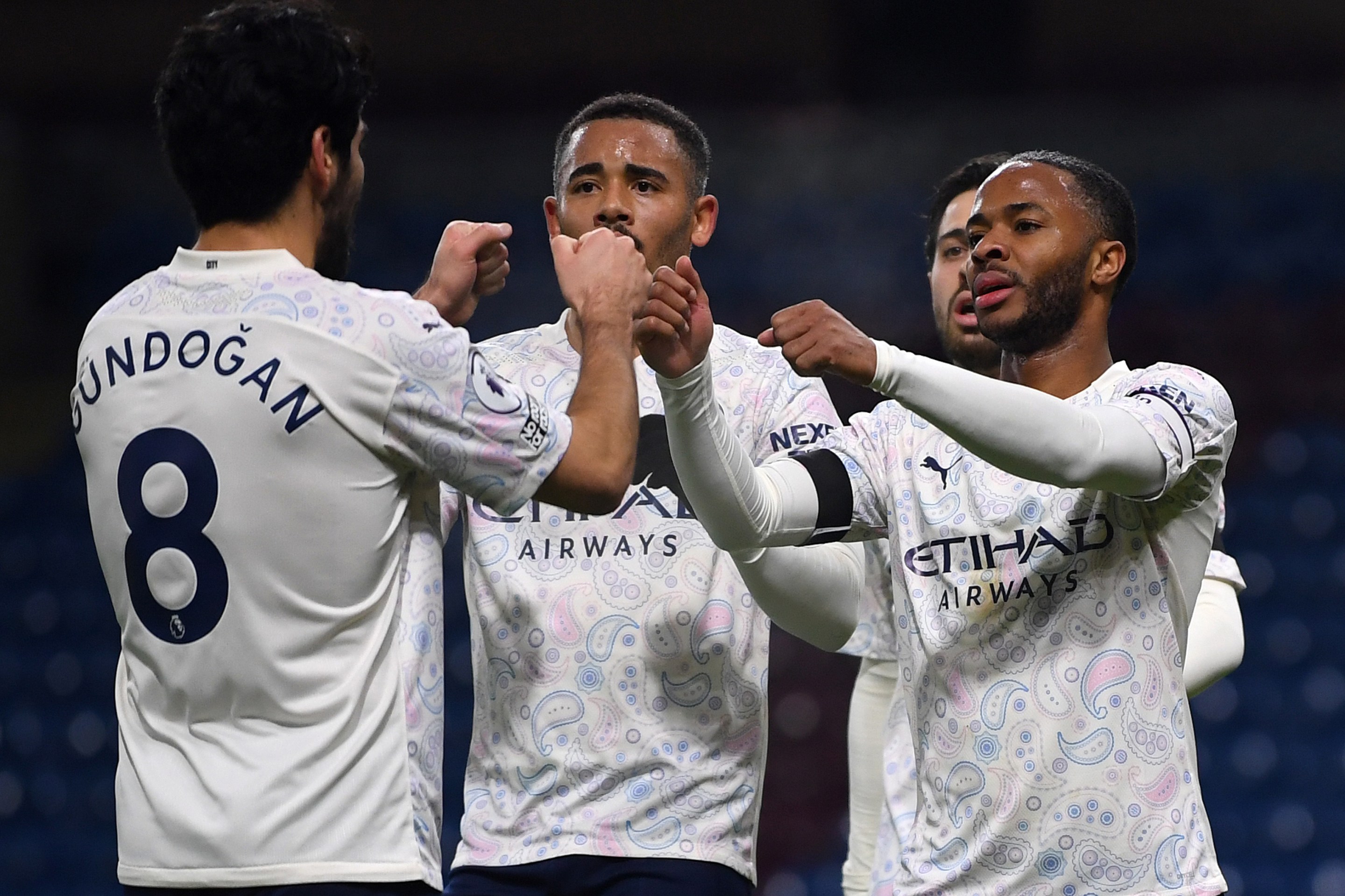 Manchester City's English midfielder Raheem Sterling (R) celebrates scoring his team's second goal with Manchester City's Brazilian striker Gabriel Jesus (C) during the English Premier League football match between Burnley and Manchester City at Turf Moor in Burnley, north west England on February 3, 2021.