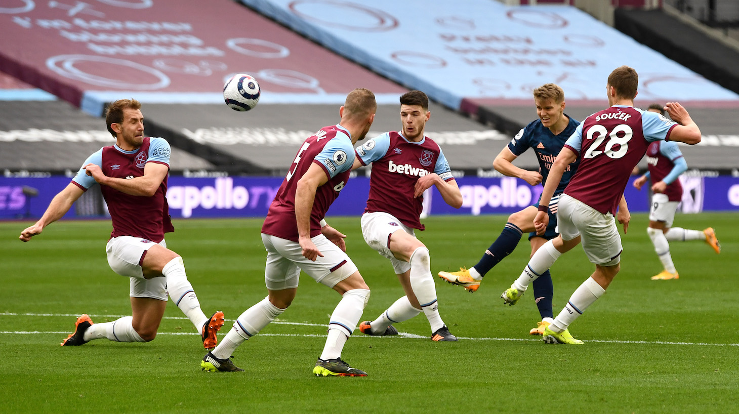 Martin Odegaard of Arsenal has a shot on goal whilst under pressure from Declan Rice and Tomáš Souček of West Ham United during the Premier League match between West Ham United and Arsenal at London Stadium on March 21, 2021 in London, England.