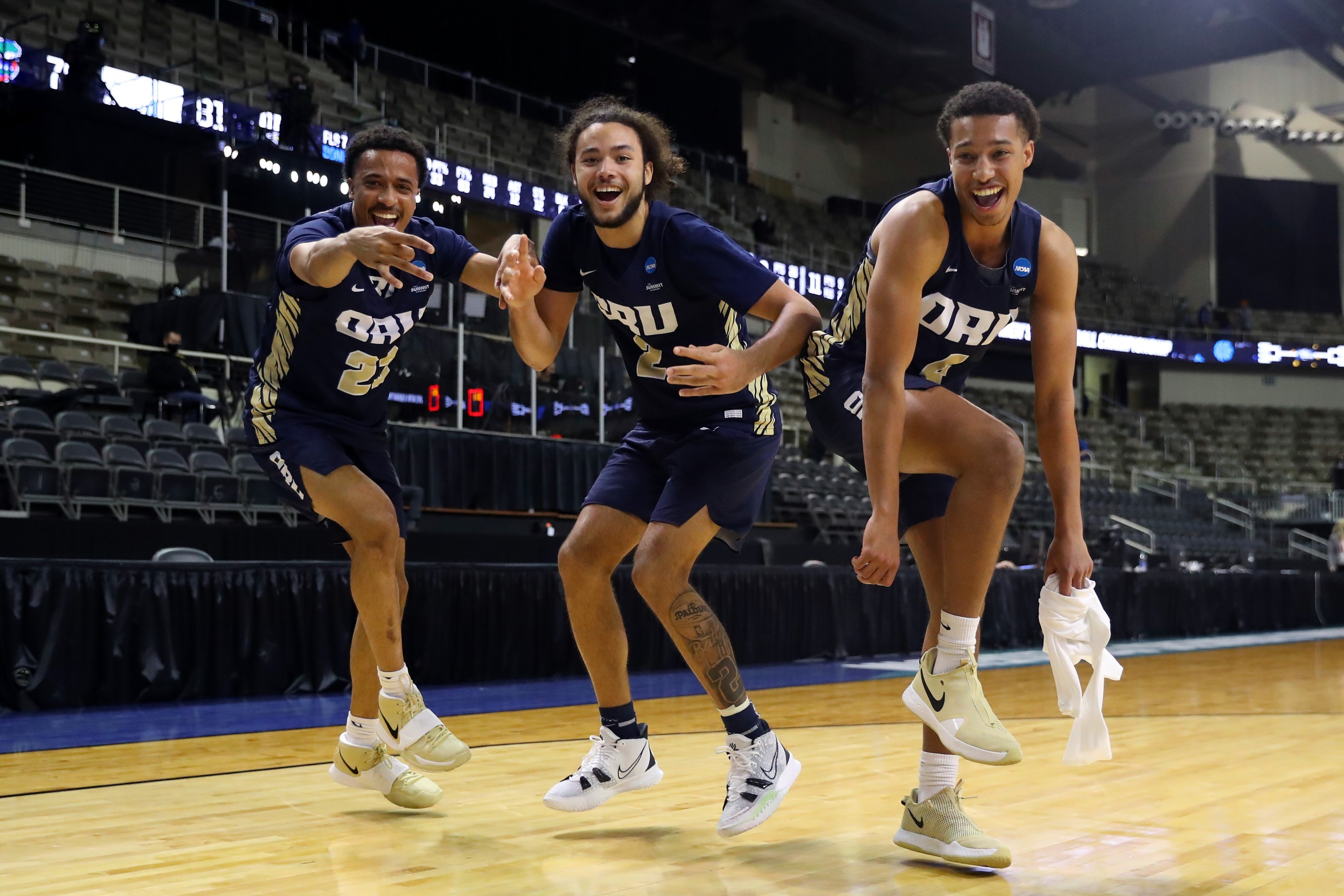 Three Oral Roberts Golden Eagles players dance after their second-round NCAA Tournament win against Florida.