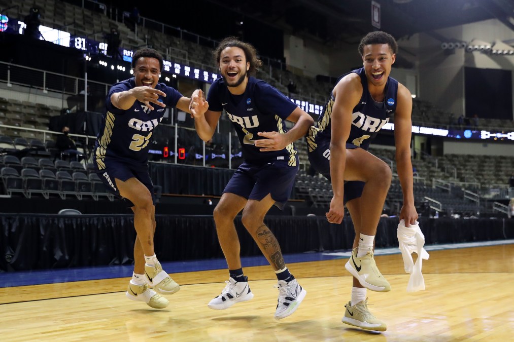 Three Oral Roberts Golden Eagles players dance after their second-round NCAA Tournament win against Florida.