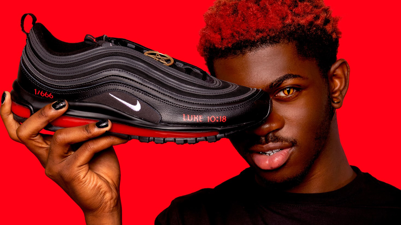Lil Nas X, holding up a pair of the Blood Shoes