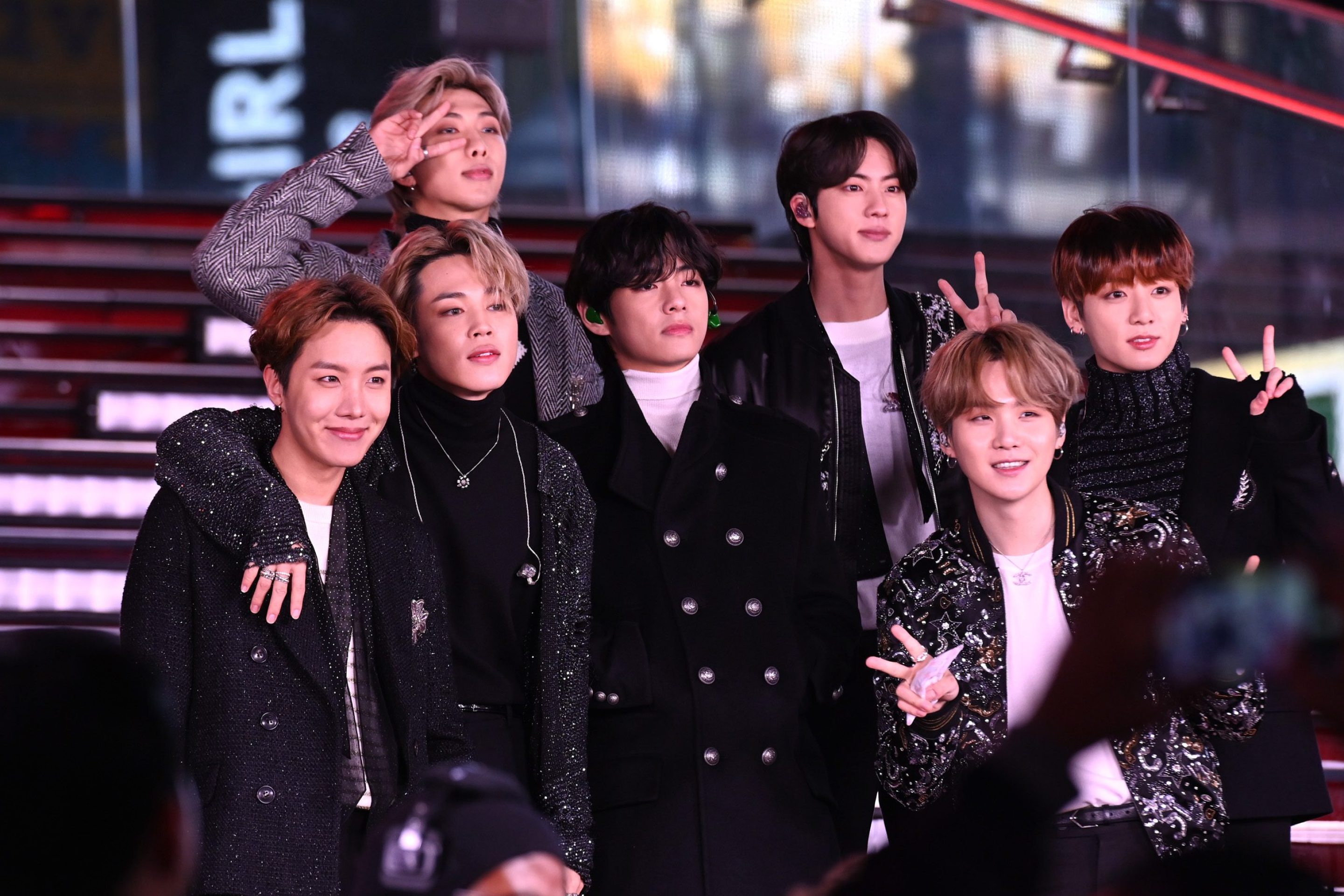 BTS performs during Dick Clark's New Year's Rockin' Eve With Ryan Seacrest 2020 on December 31, 2019 in New York City. All seven members are standing on a lighted staircase and smiling after their performance.