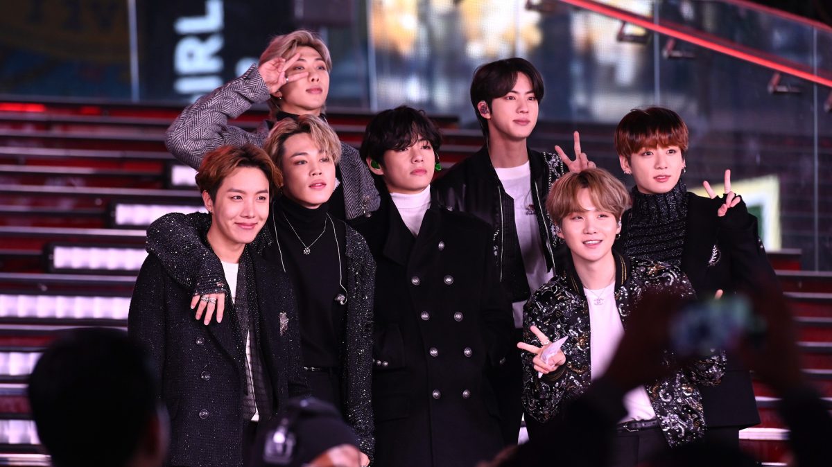 BTS performs during Dick Clark's New Year's Rockin' Eve With Ryan Seacrest 2020 on December 31, 2019 in New York City. All seven members are standing on a lighted staircase and smiling after their performance.