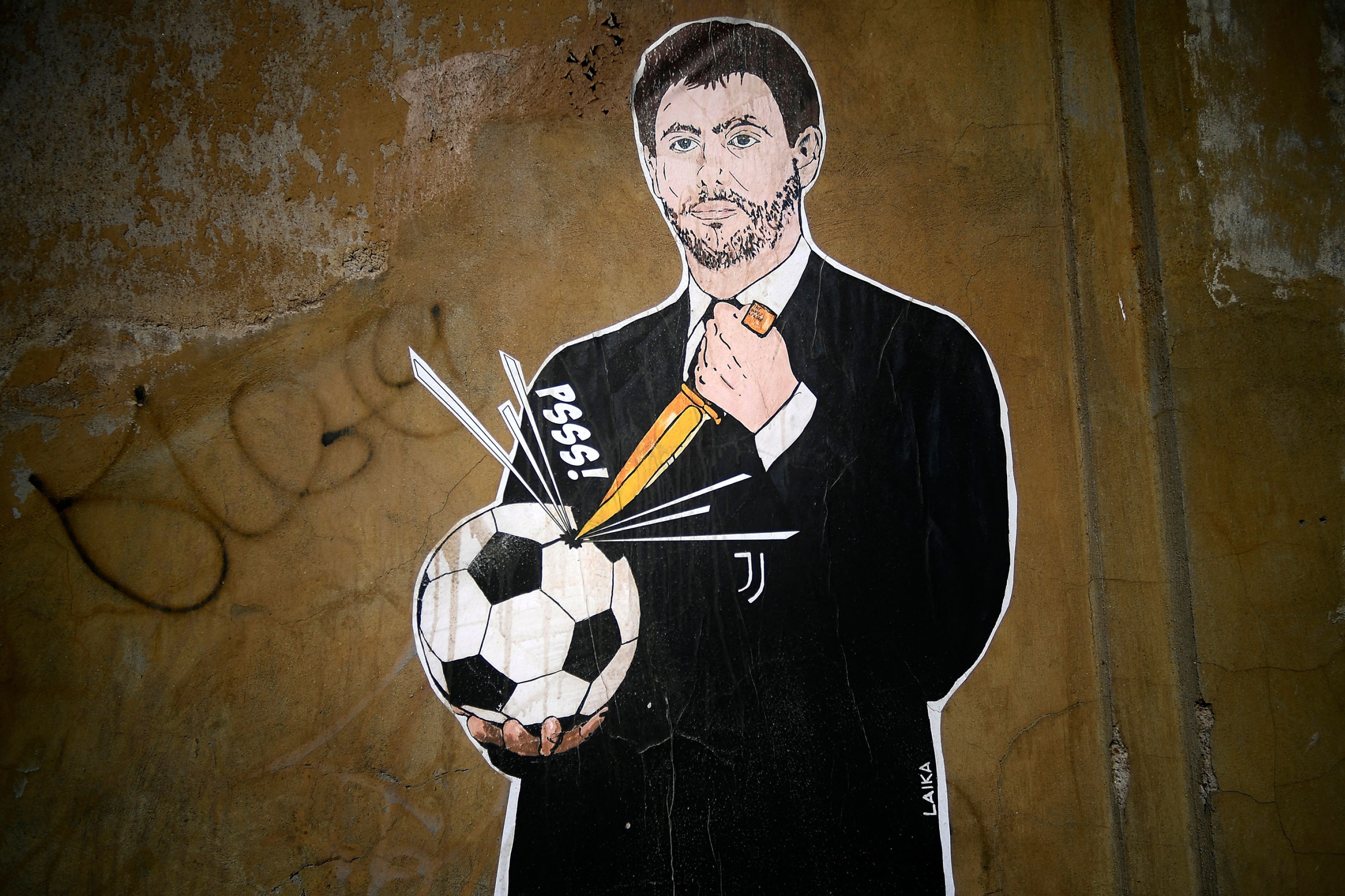A photo shows a grafiti entitled "The failed coup" (Il Golpe Fallito) by Italian artist Laika, showing Juventus President Andrea Agnelli puncturing a football, near the headquarters of the Italian Football Federation in Rome on April 21, 2021.