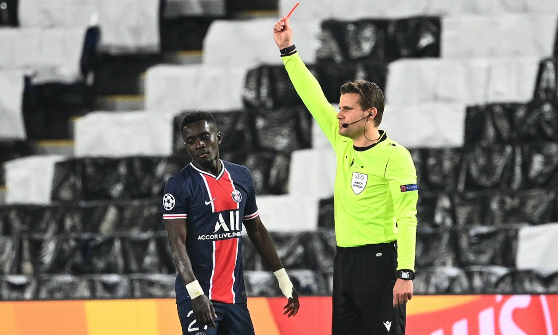 Referee Felix Brych (R) shows a red card to Paris Saint-Germain's Senegalese midfielder Idrissa Gueye during the UEFA Champions League first leg semi-final football match between Paris Saint-Germain (PSG) and Manchester City at the Parc des Princes stadium in Paris on April 28, 2021. (Photo by Anne-Christine POUJOULAT / AFP) (Photo by ANNE-CHRISTINE POUJOULAT/AFP via Getty Images)