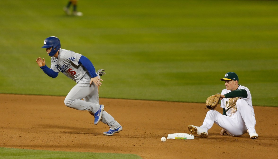 OAKLAND, CALIFORNIA - APRIL 05: Will Smith #16 of the Los Angeles Dodgers runs to third base after colliding with Matt Chapman #26 of the Oakland Athletics in the top of the eighth inning at RingCentral Coliseum on April 05, 2021 in Oakland, California. (Photo by Lachlan Cunningham/Getty Images)
