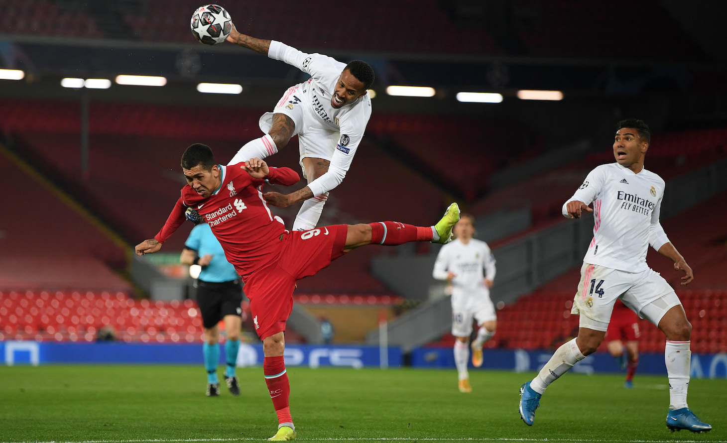 Roberto Firmino of Liverpool battles for possession with Eder Militao of Real Madrid during the UEFA Champions League Quarter Final Second Leg match between Liverpool FC and Real Madrid at Anfield on April 14, 2021 in Liverpool, England.