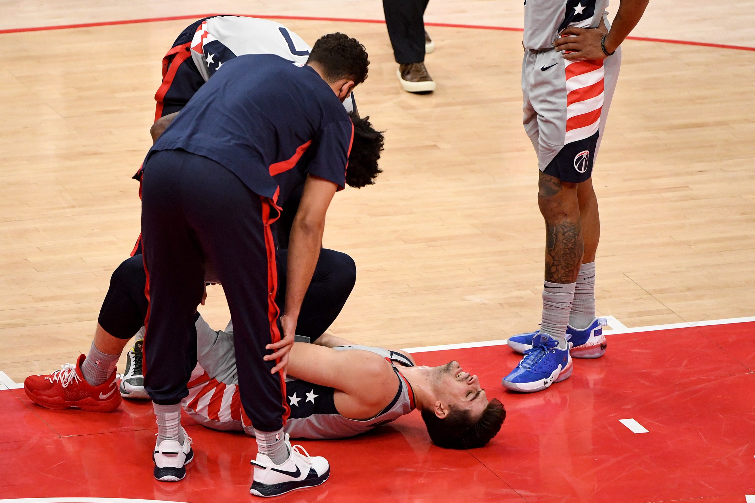 Wizards rookie Deni Avdija lies injured on the court.
