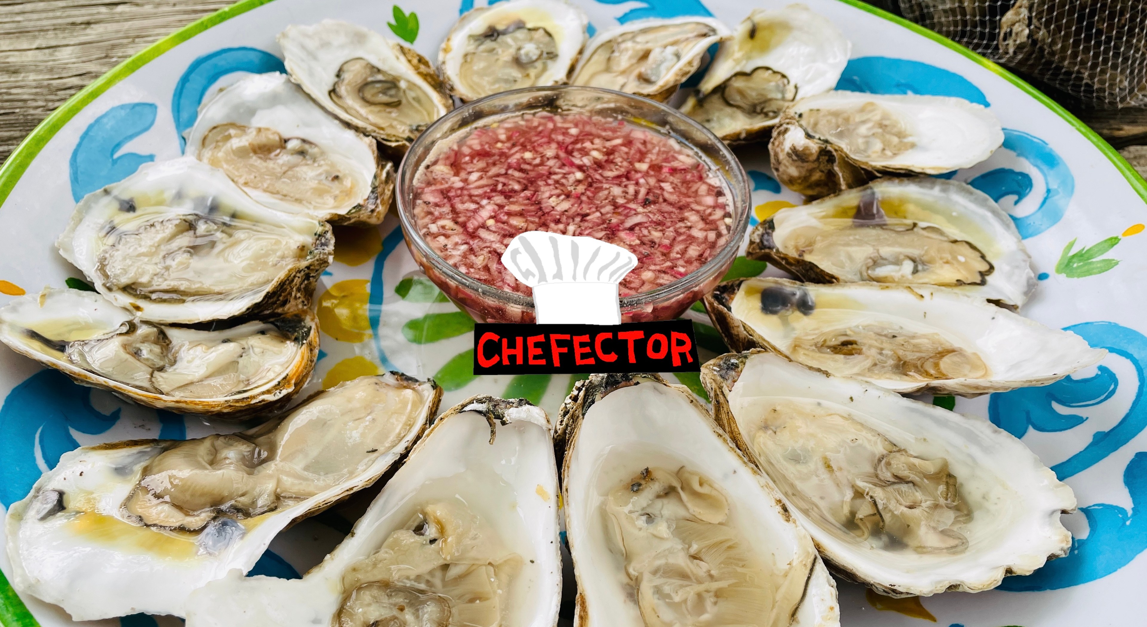 A plate of oysters, a bowl of mignonette sauce, and the Chefector badge