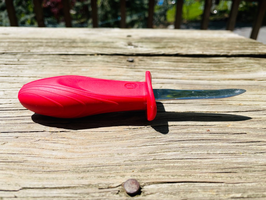 A New Haven-style oyster knife with a red handle