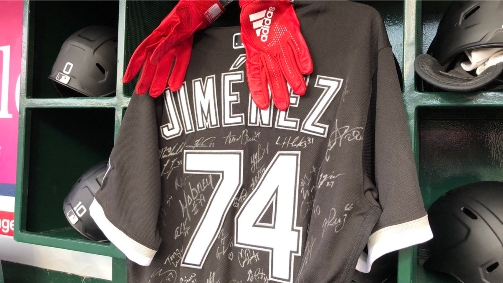 A jersey of Eloy Jimenez, with his batting gloves, signed by his teammates and hung in the dugout during Thursday's season-opener.