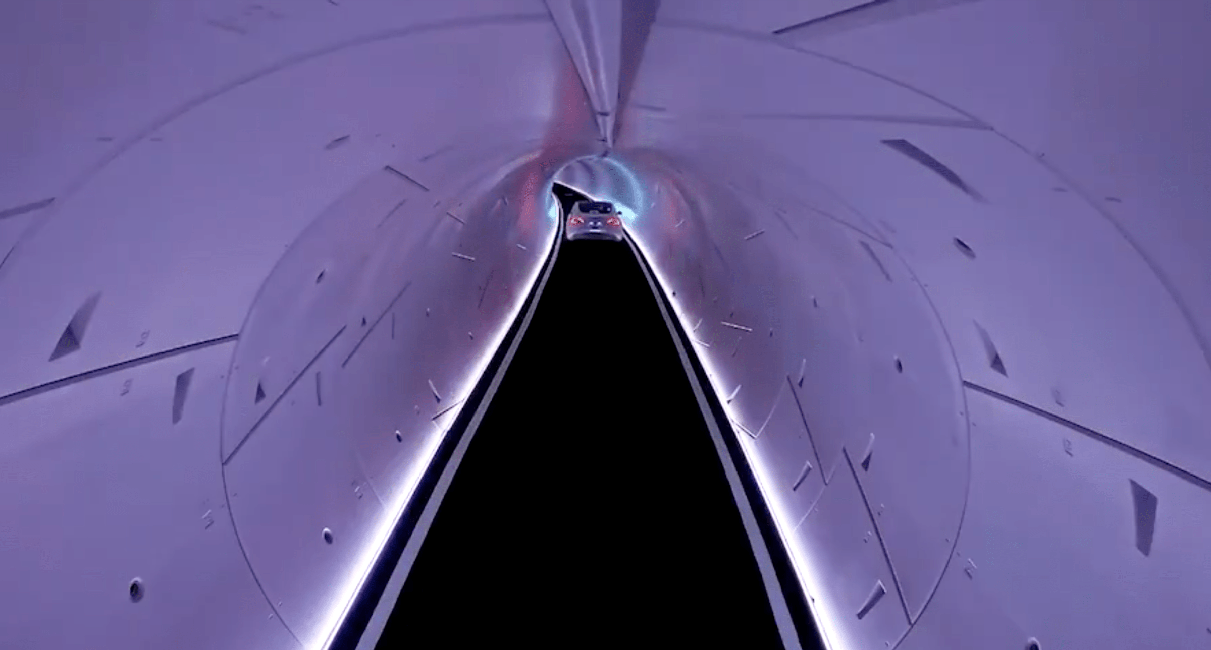 A single Tesla sedan drives through a tunnel