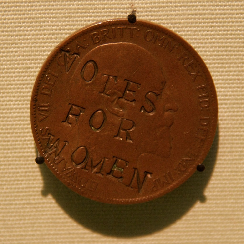 A suffragette-defaced penny is stamped with "VOTES FOR WOMEN."