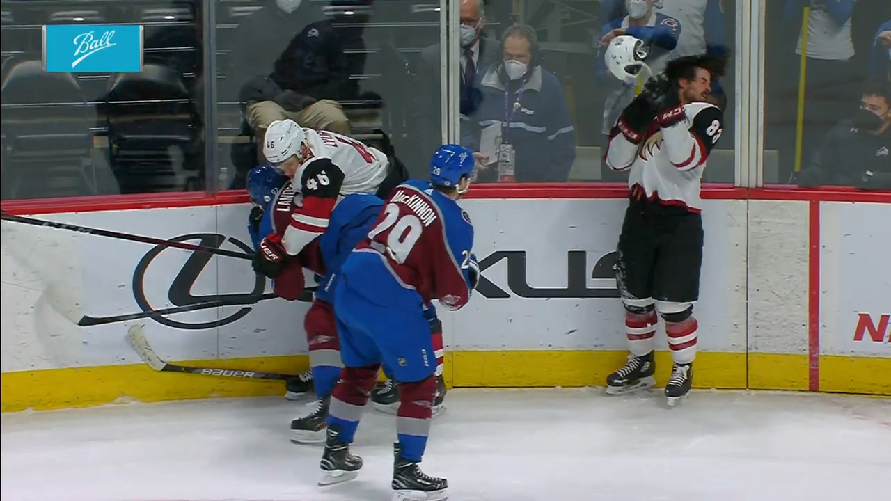 Nathan MacKinnon tosses Conor Garland's helmet back at his chest.