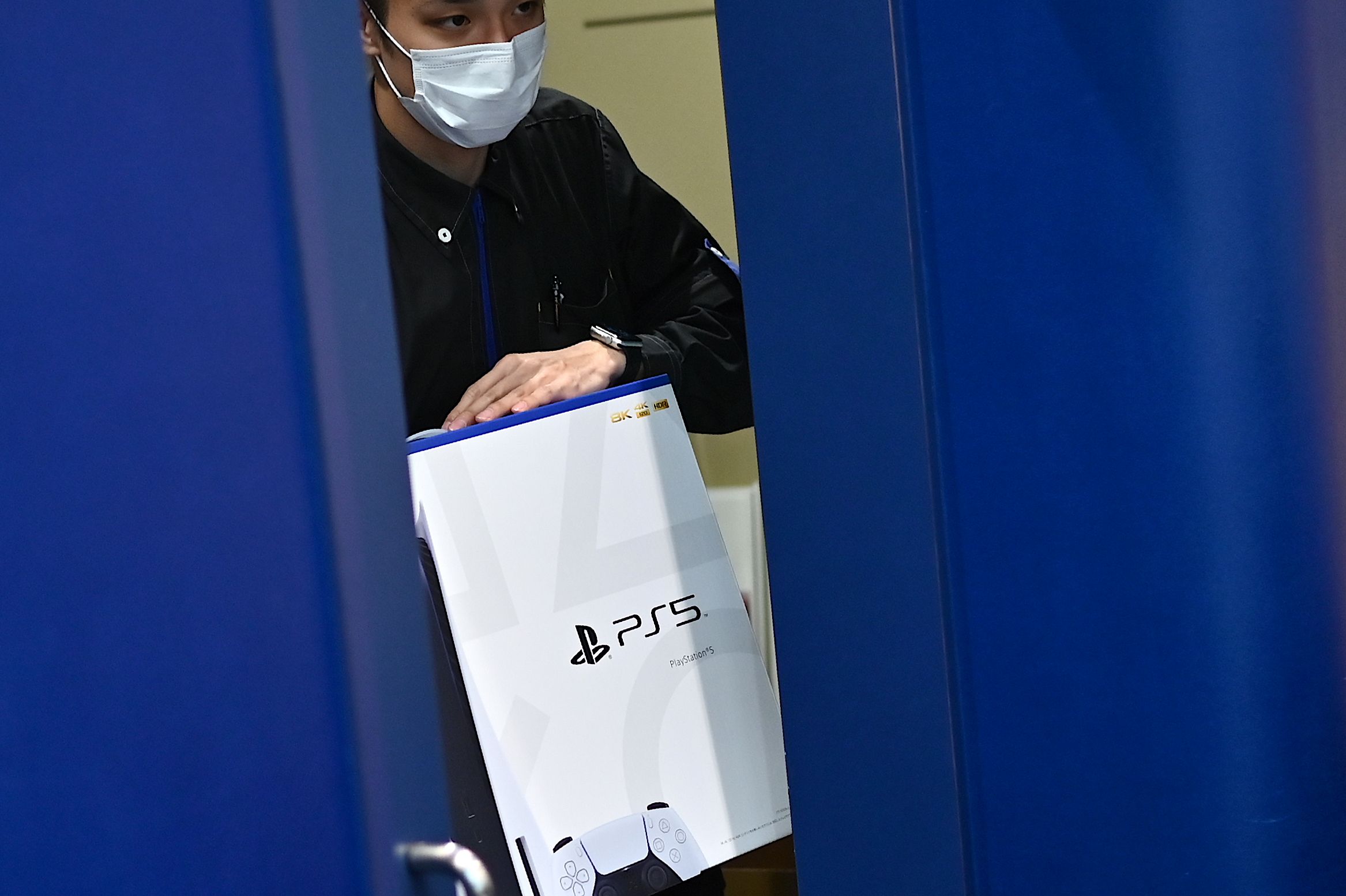 An employee rolls out the new Sony PS5 in Japan.