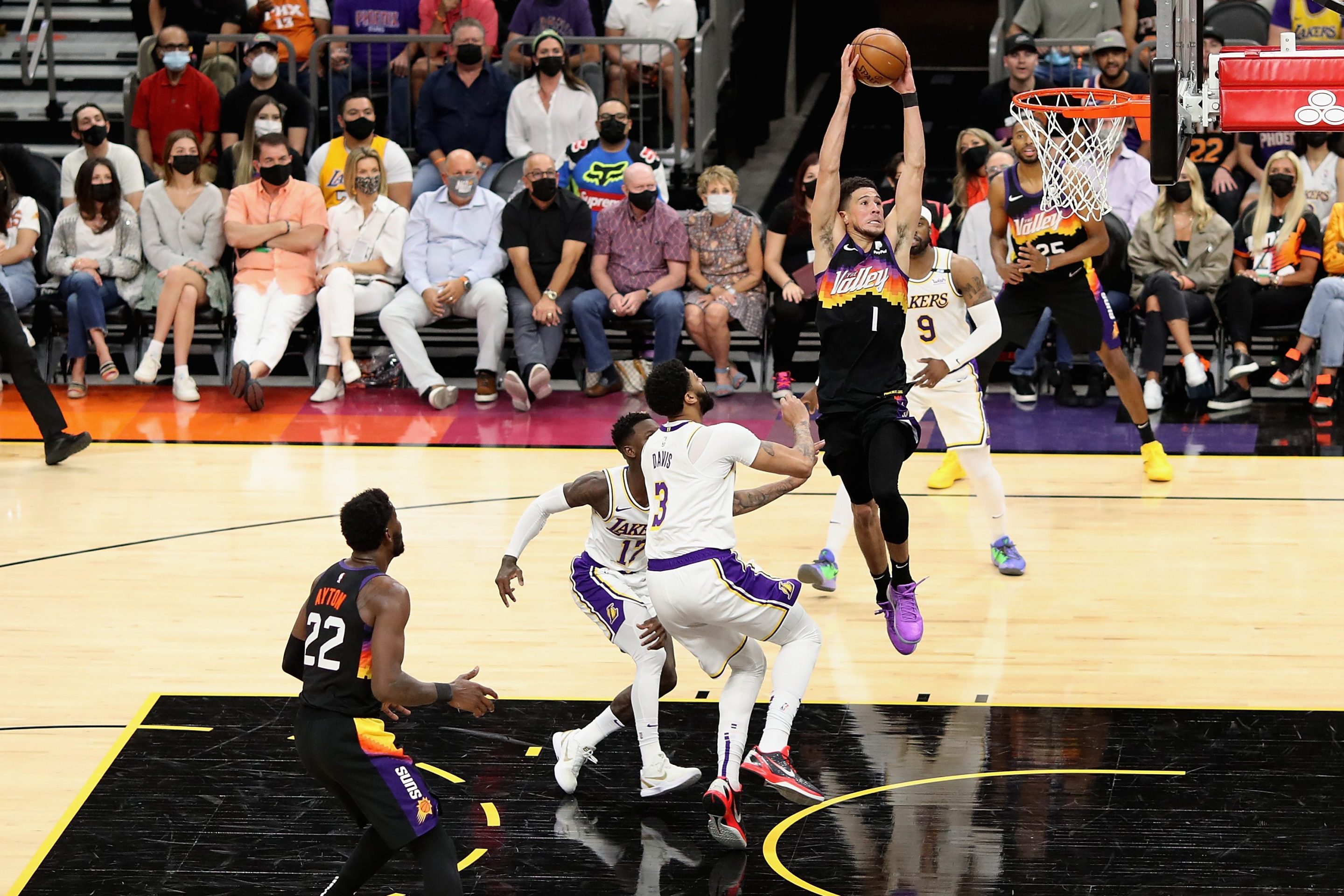 Devin Booker #1 of the Phoenix Suns slam dunks the ball past Anthony Davis #3 of the Los Angeles Lakers during the first half of Game One of the Western Conference first-round playoff series at Phoenix Suns Arena on May 23, 2021 in Phoenix, Arizona. The Suns defeated the Lakers 99-90.